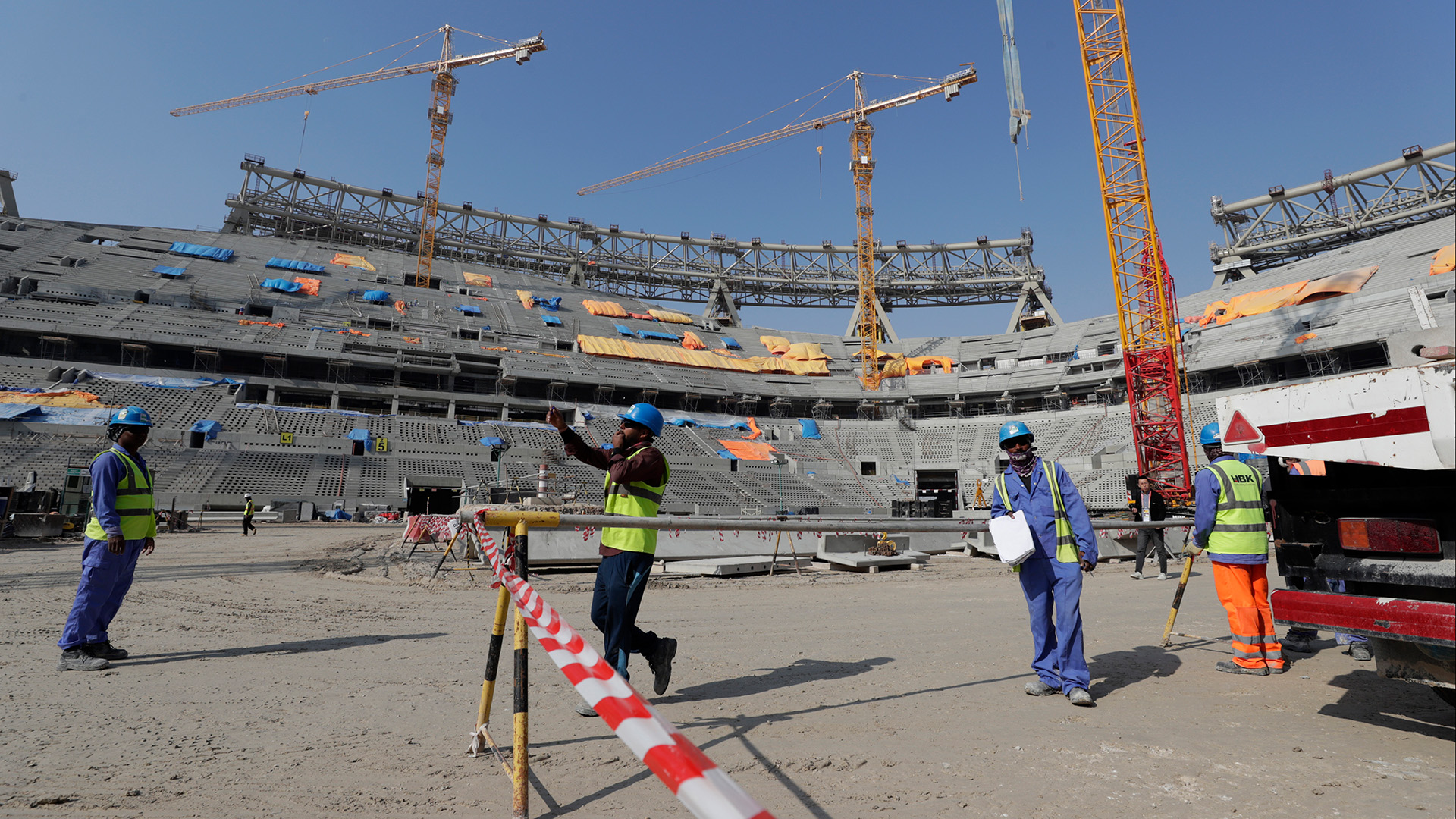 Bauarbeiter arbeiten am Lusail-Stadion, einem der Stadien der WM 2022 in Katar. | dpa