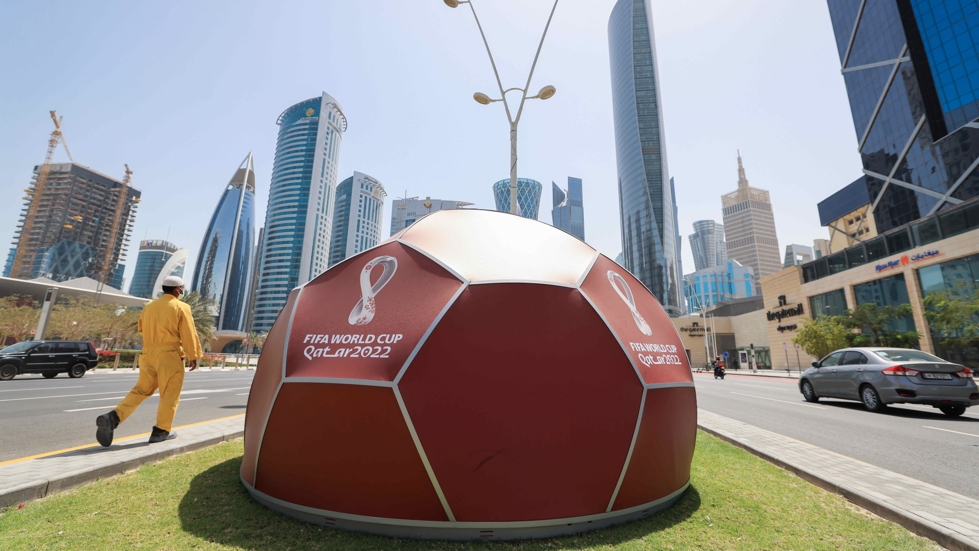 Ein Werbedisplay für die WM steht auf einem Grünstreifen zwischen Fahrbahnen in Doha. | dpa