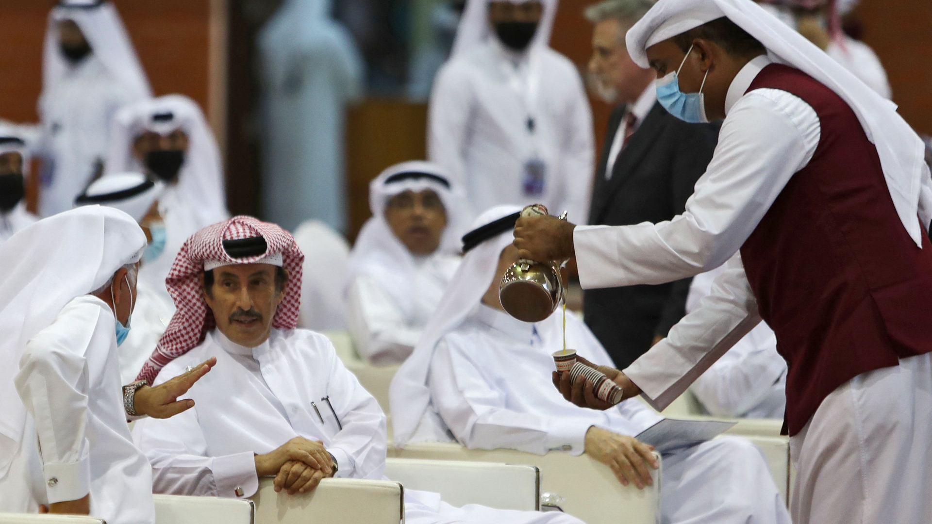 Ein Kellner serviert auf einer Wahlkampfveranstaltung in Katar den teilnehmenden Männern Tee | AFP