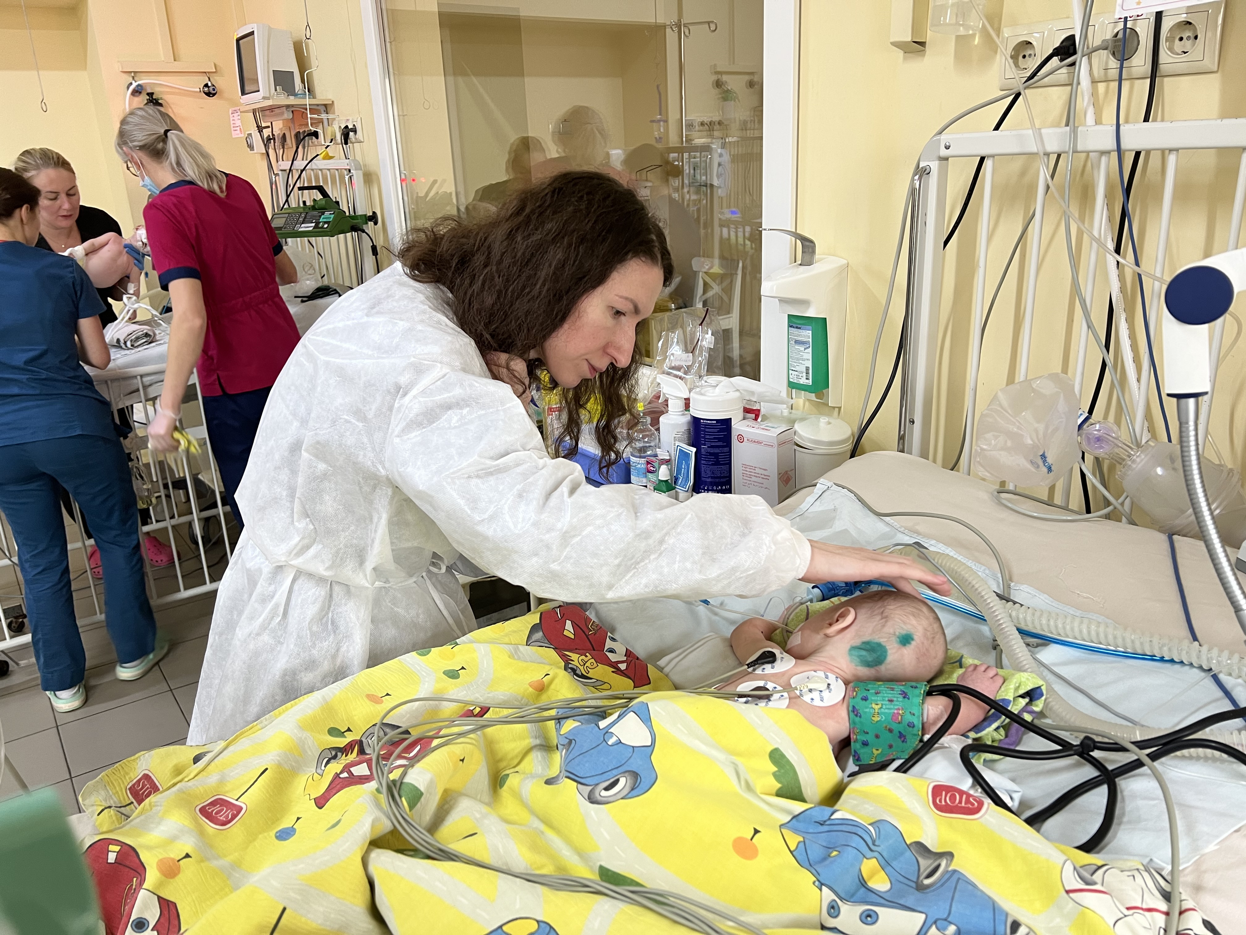 Mutter Sophia streicht ihrer Tochter Sophia über den Kopf. Das Baby liegt in einem Krankenhausbettchen und ist an EKG-Elektroden angeschlossen. | Björn Blaschke