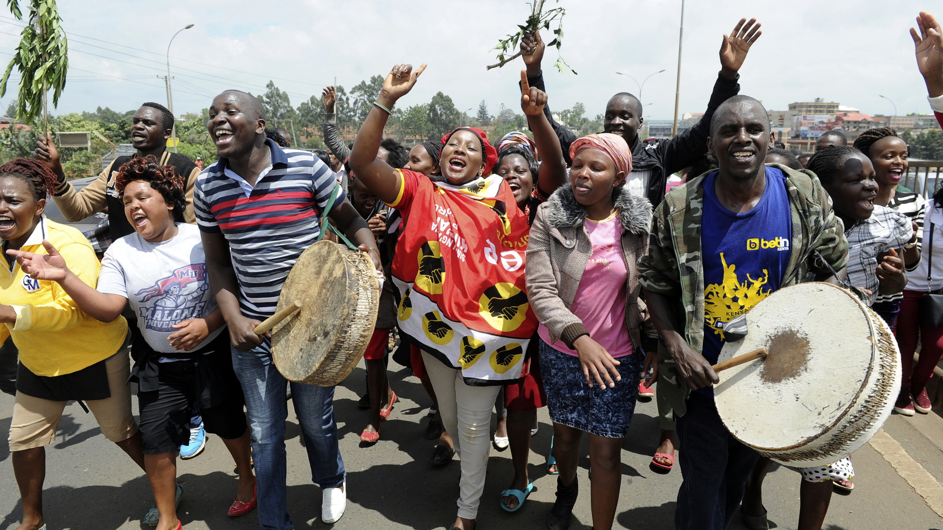 Unterstützer des kenianischen Präsidenten Kenyatta ziehen feiernd durch eine Straße von Nairobi. | dpa