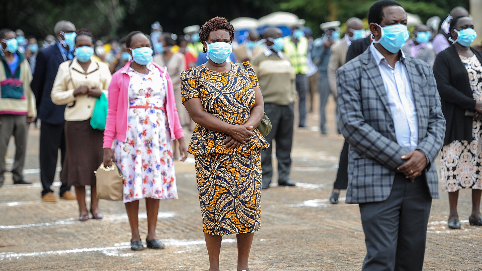 Arbeiter mit Mundschutz stehen in Nairobi (Kenia) in Sicherheitsabstand zueinander an, um ihre Arbeitsverträge verlängern zu lassen. | dpa