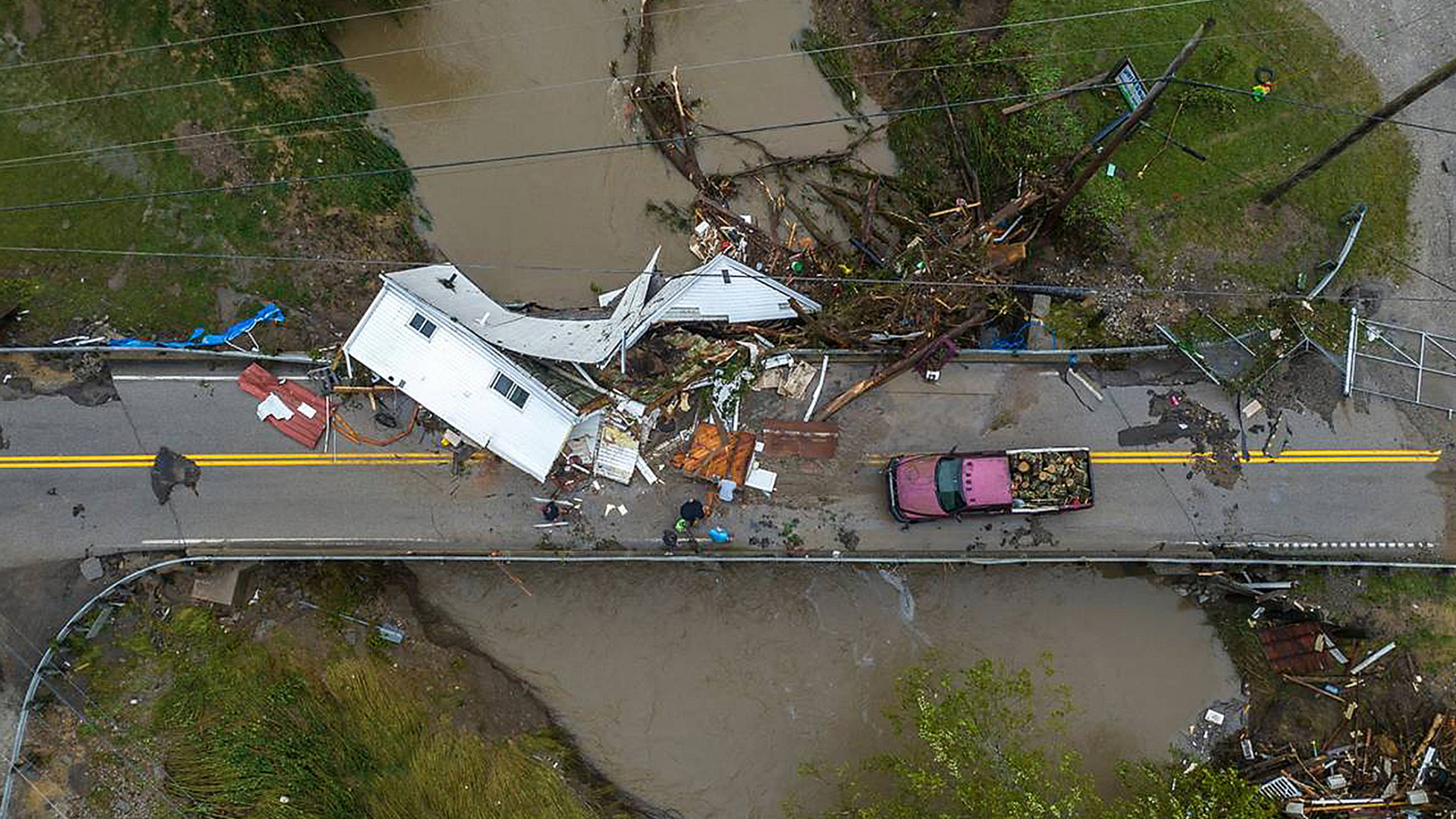 Helfer arbeiten nahe Whitesburg, Kentucky daran, ein zerstörtes Haus von einer Brücke zu räumen. | dpa