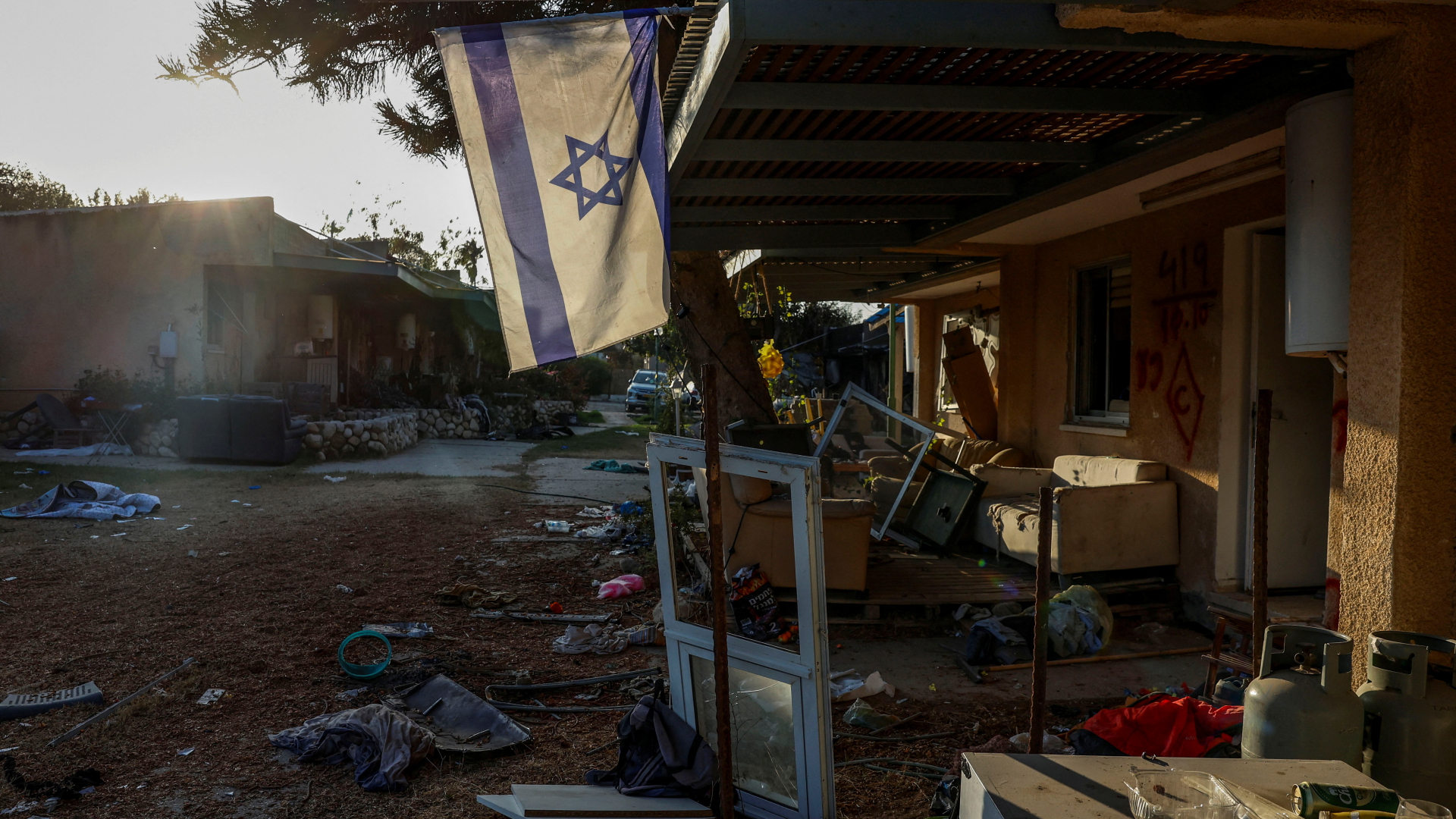 Eine Israel-Flagge vor einem zerstörten Gebäude im Kibbuz Kfar Aza.