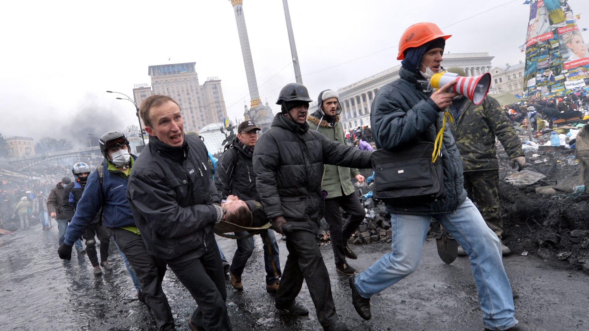 Demonstranten tragen am 20. Februar 2014 einen Verwundeten vom Maidan in Kiew (Ukraine)