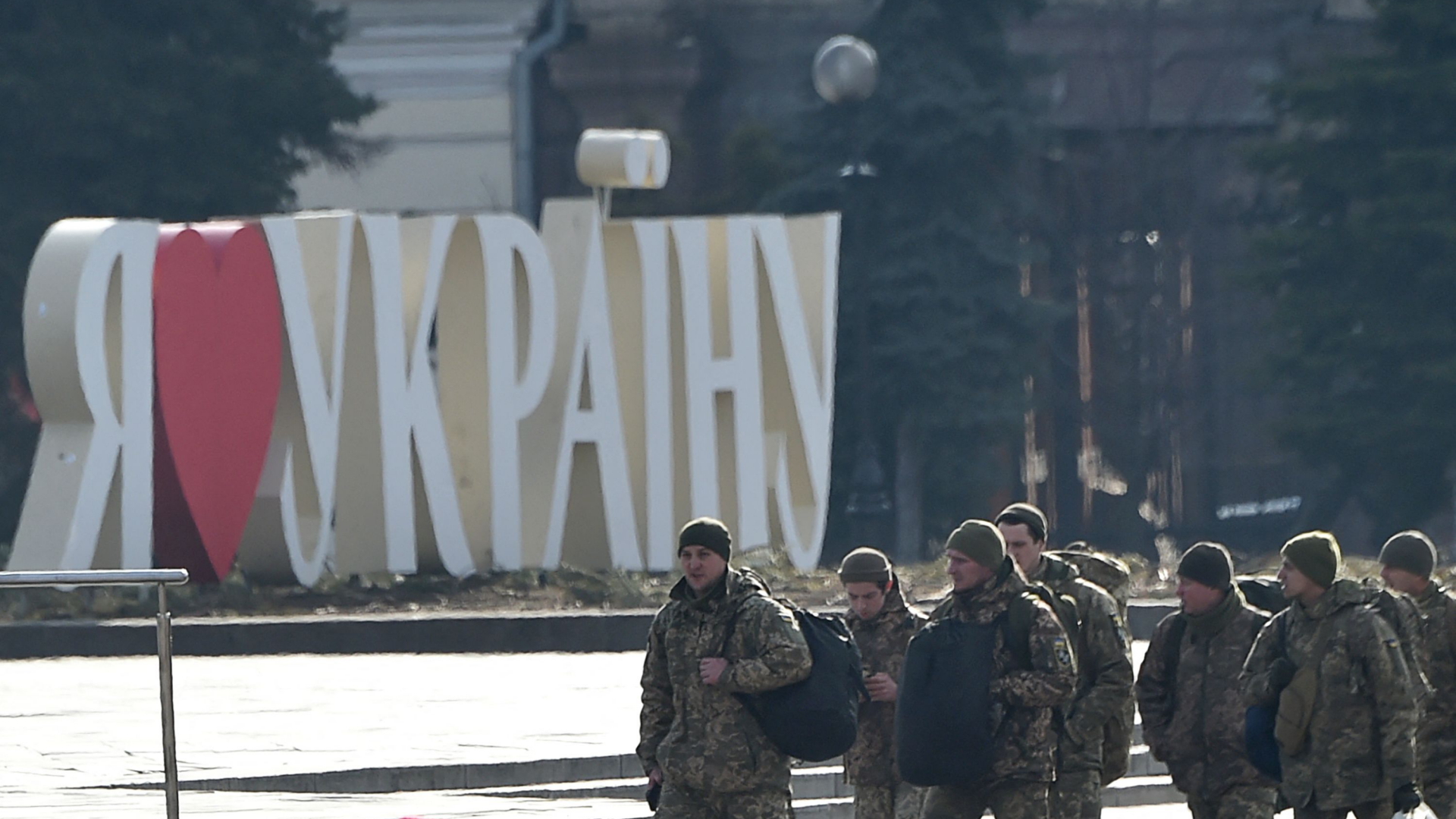 Ukrainische Soldaten auf dem zentralen Maidan Nesaleschnosti in Kiew gehen am Schriftzug "Ich liebe die Ukraine" vorbei. | AFP