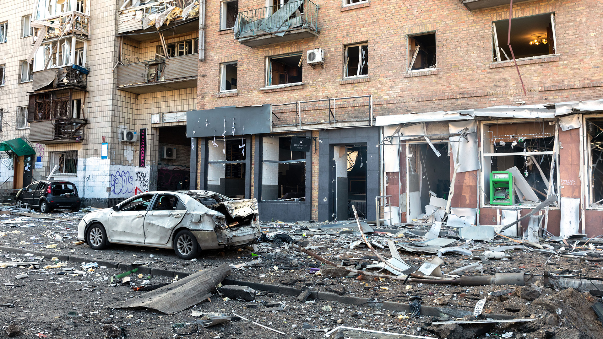 Zerstörte Autos und Gebäude auf einer Straße in Kiew.