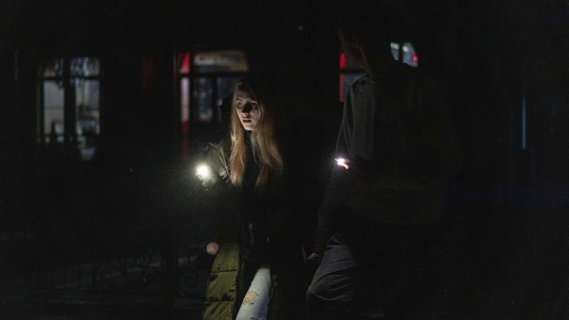 Ein junges Paar spaziert durch das Stadtzentrum, das nach einem russischen Raketenangriff ohne Strom ist.