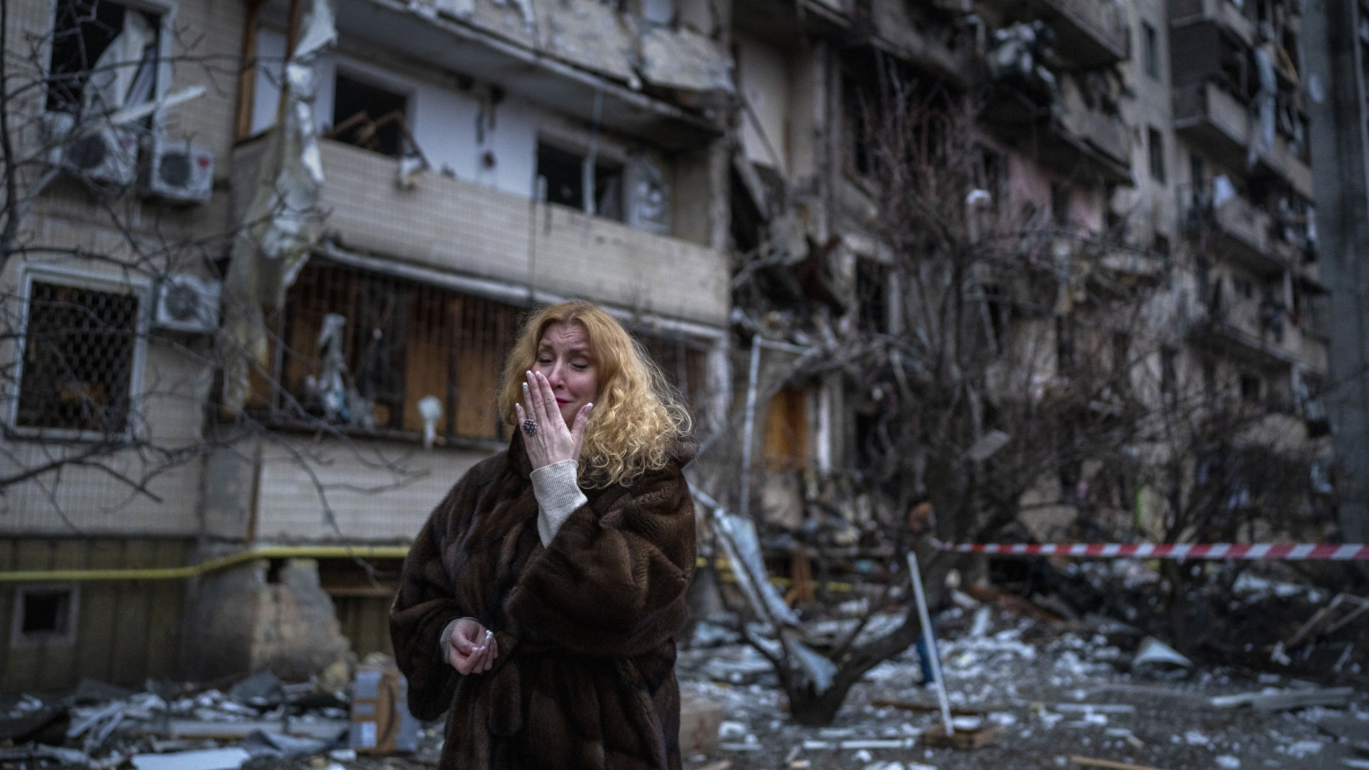 Eine Frau steht vor einem zerstörten Wohnhaus in der ukrainischen Hauptstadt Kiew. | AP