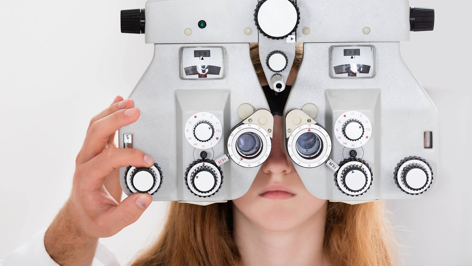 Ein Kind hinter einem Optometrist in einer Augenarztpraxis | picture alliance / PantherMedia