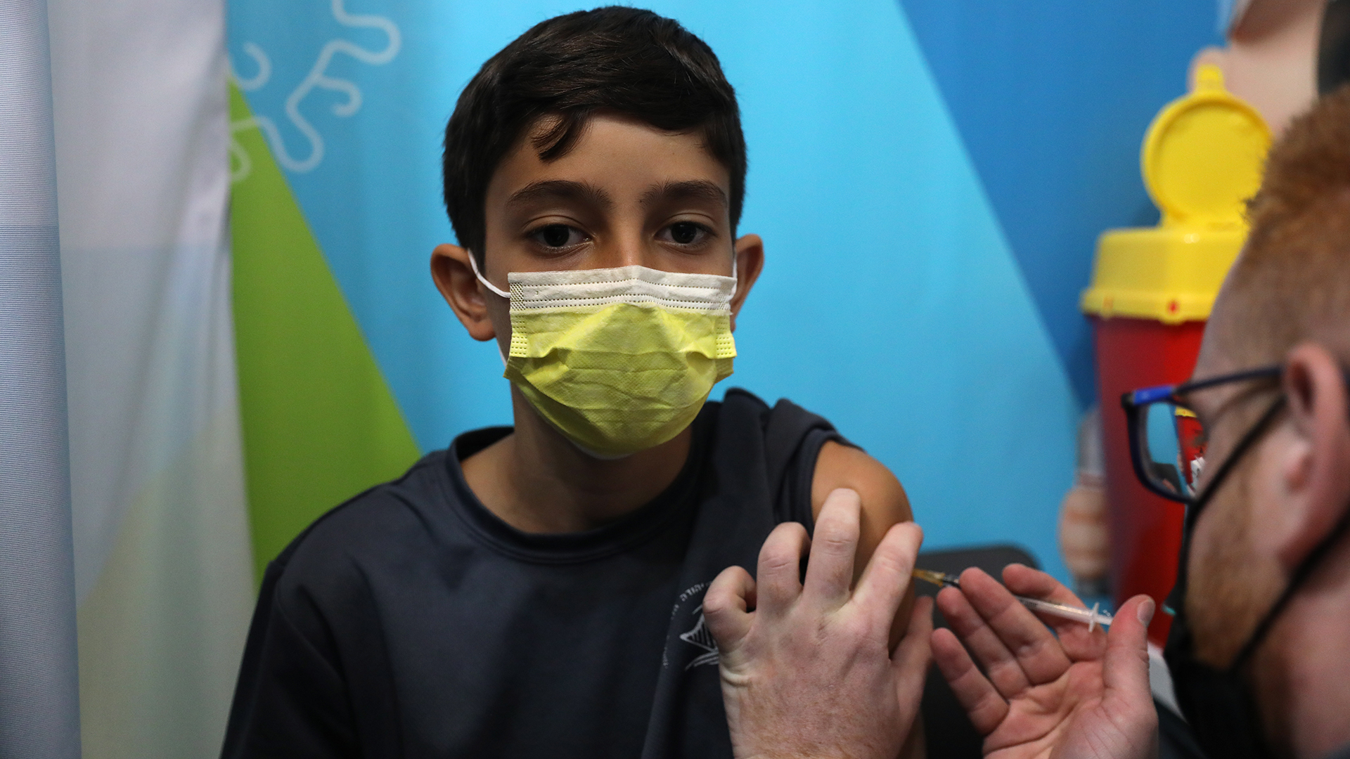 Ein israelischer Mitarbeiter des Gesundheitswesens injiziert einem Kind eine Spritze mit dem Impfstoff COVID-19 in Jerusalem. | EPA