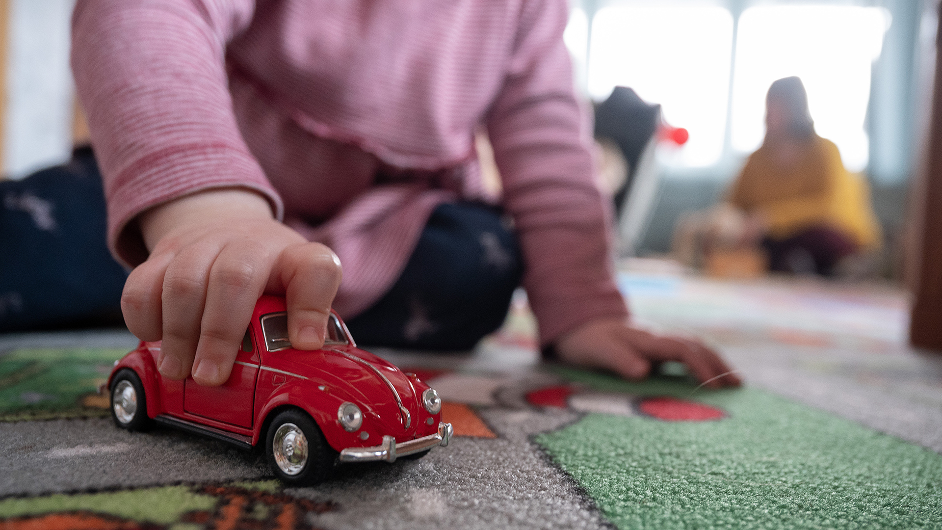 Kind spielt mit einem Spielzeugauto | picture alliance/dpa