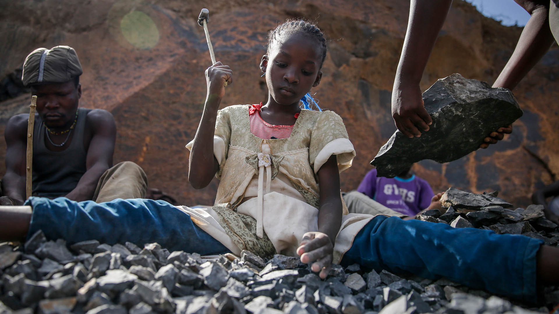 Ein Kind bricht mit einem Hammer Steine in Nairobi. | AP