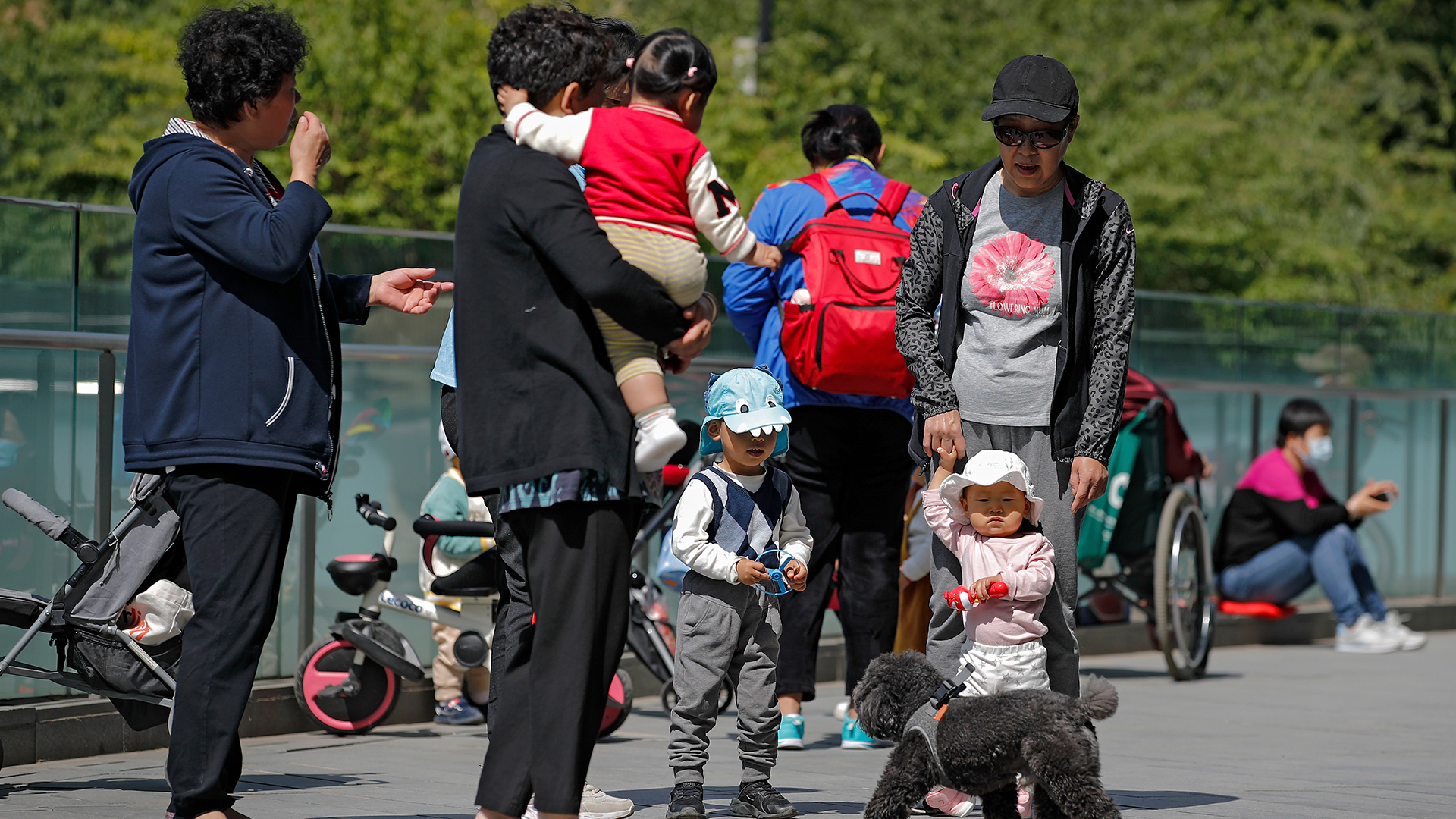 Kinder und Eltern stehen in Peking zusammen in einer Gruppe. | dpa