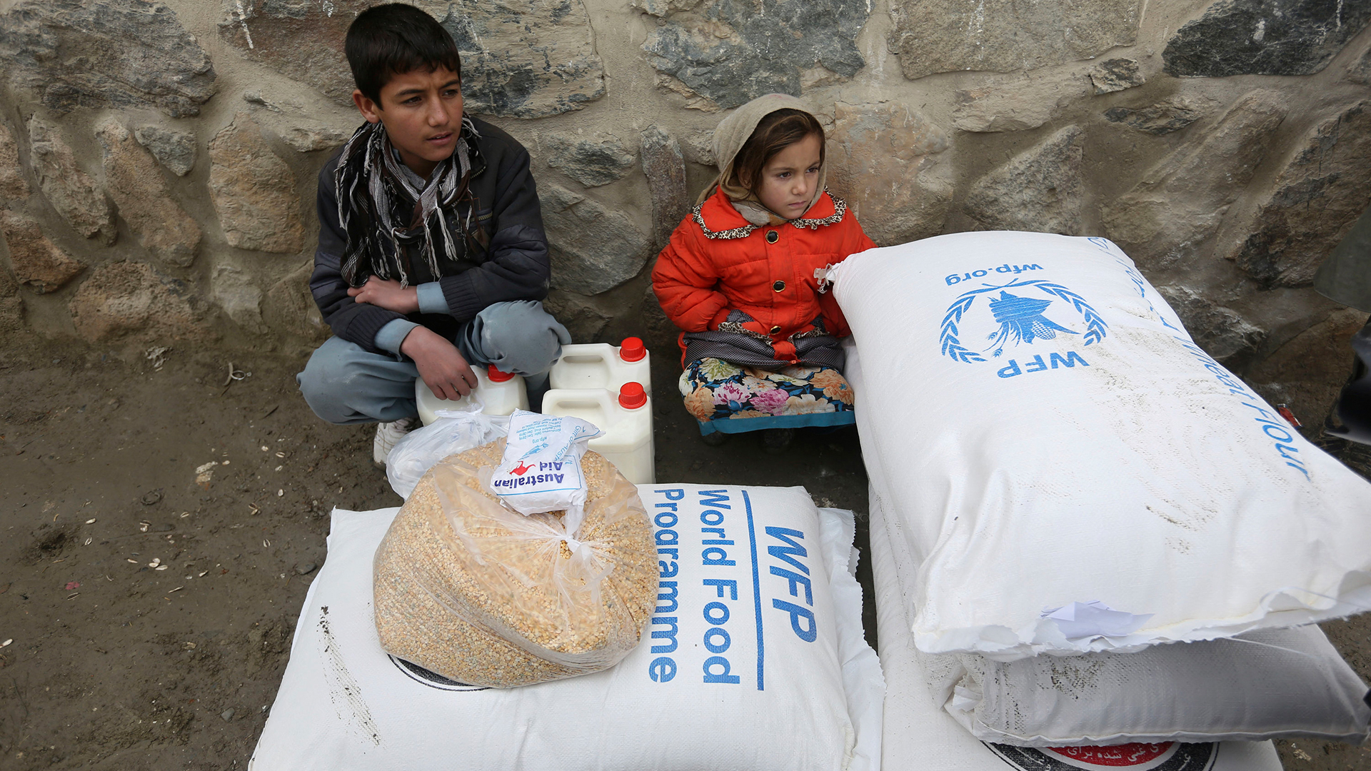 Kinder warten in Kabul (Afghanistan) auf einen Transport, nachdem sie vom Welternährungsprogramm gespendete Lebensmittel erhalten haben.  | AP