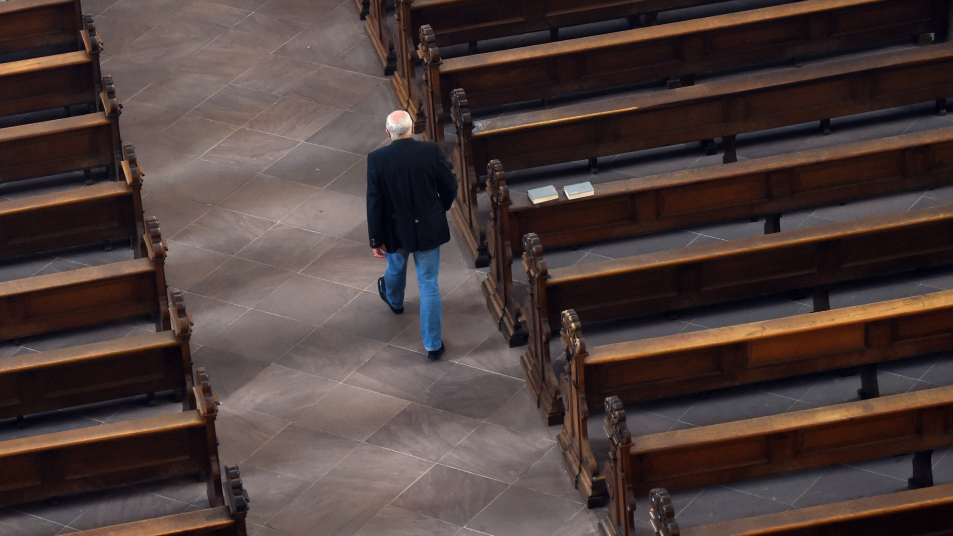  Ein Mann geht im Dom in Fulda (Hessen) an leeren Kirchenbänken vorbei. | dpa