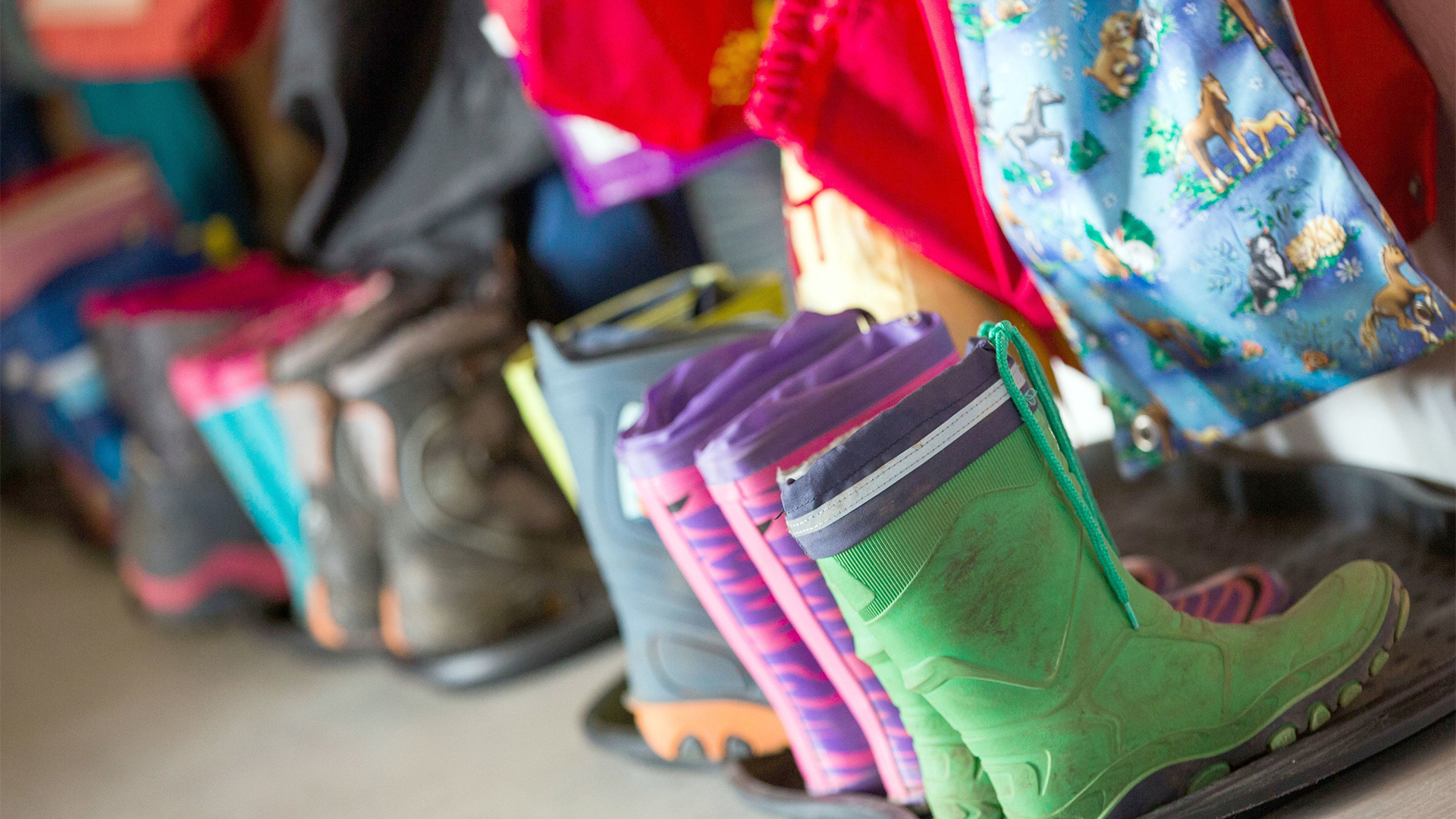 Gummistiefel für Kinder stehen in der Garderobe einer Kindertagesstätte | Bildquelle: dpa