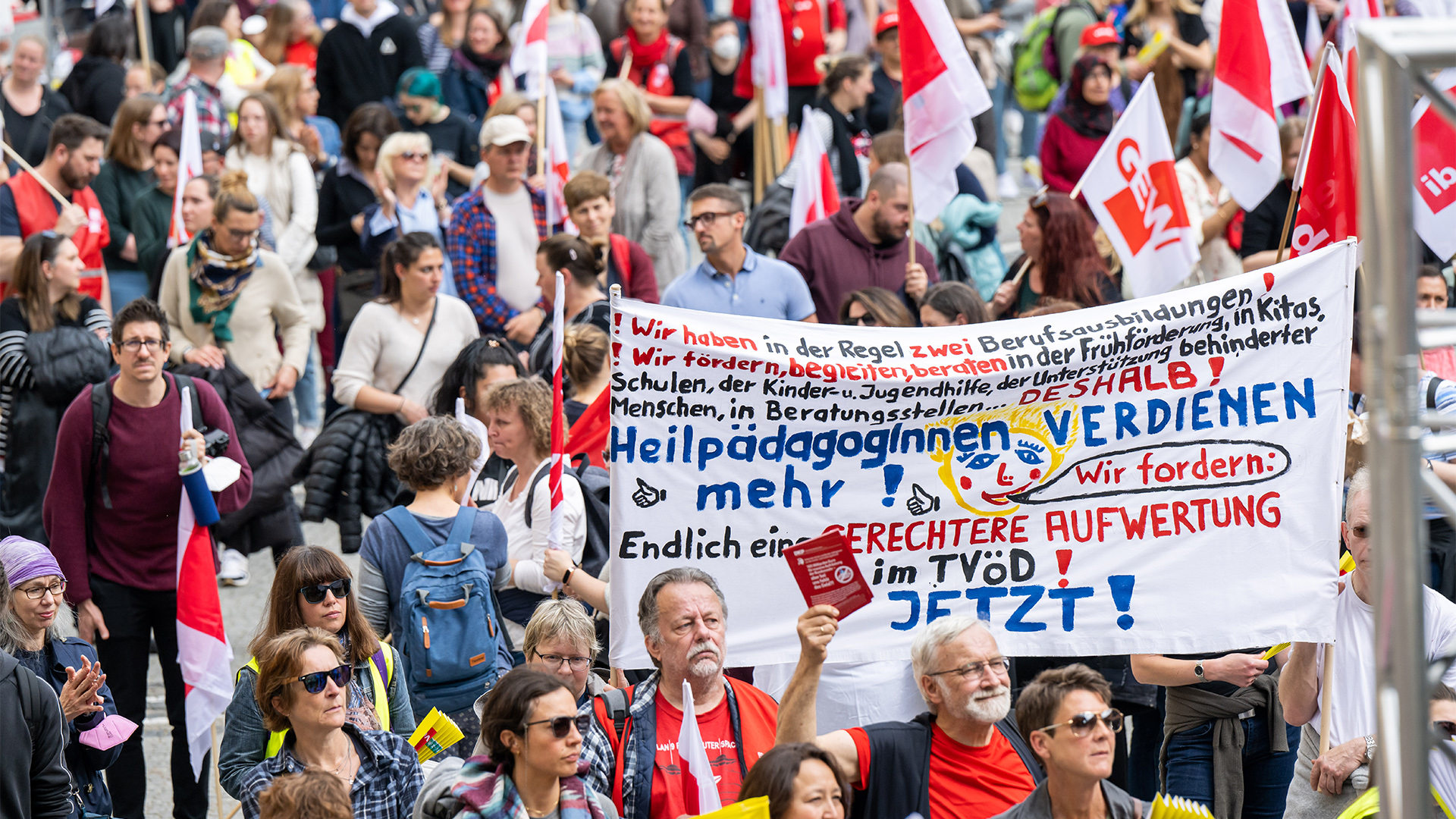 Erzieher und Erzieherinnen demonstrieren in München mit Plakaten und Flaggen. | dpa