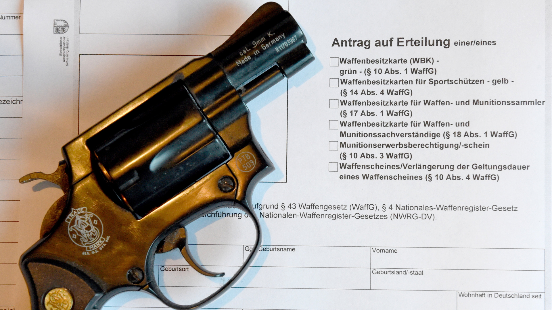 Ein Revolver liegt auf einem Antrag für die Ausstellung eines Waffenscheines. | dpa