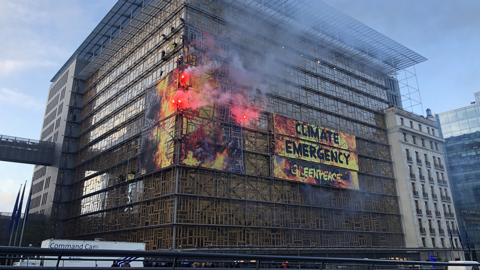 "Greenpeace"-Aktivisten haben an einer Fassade in Brüssel ein riesiges Transparent mit der Aufschrift "Kliamnotstand" aufgehängt und Bengalos gezündet. | dpa