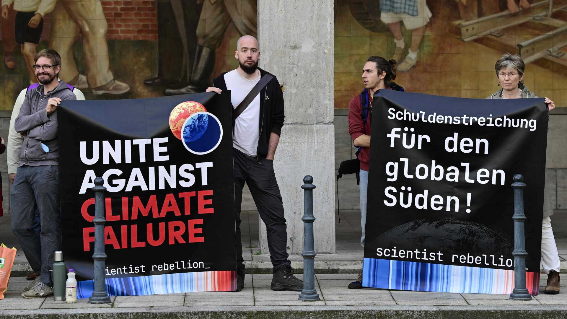 Klimaaktivisten protestieren mit Plakaten vor dem Bundesfinanzministerium in Berlin. | AFP