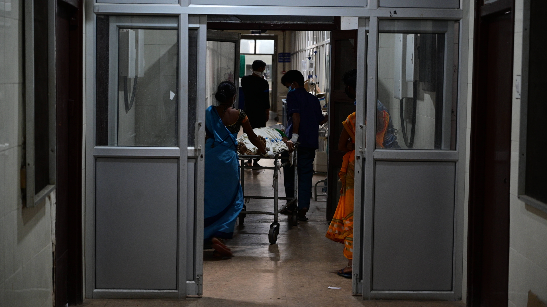 Krankenhauspersonal schiebt einen Corona-Patienten auf einer Trage durch das Swaroop Rani Neharu Krankenhaus im indischen Prayagraj. | dpa