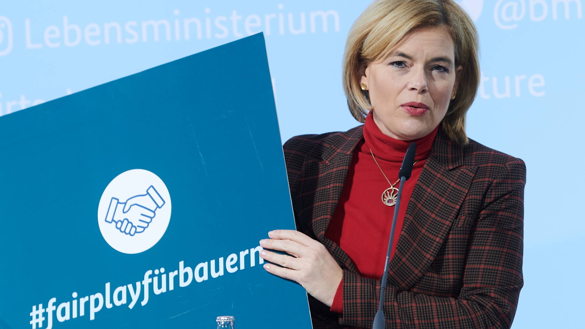 Bundeslandwirtschaftsministerin Julia Klöckner präsentiert ein Schild mit der Aufschrift "#fairplayfürbauern" während der Vorstellung eines Gesetzentwurfs gegen unfaire Handelspraktiken. | dpa