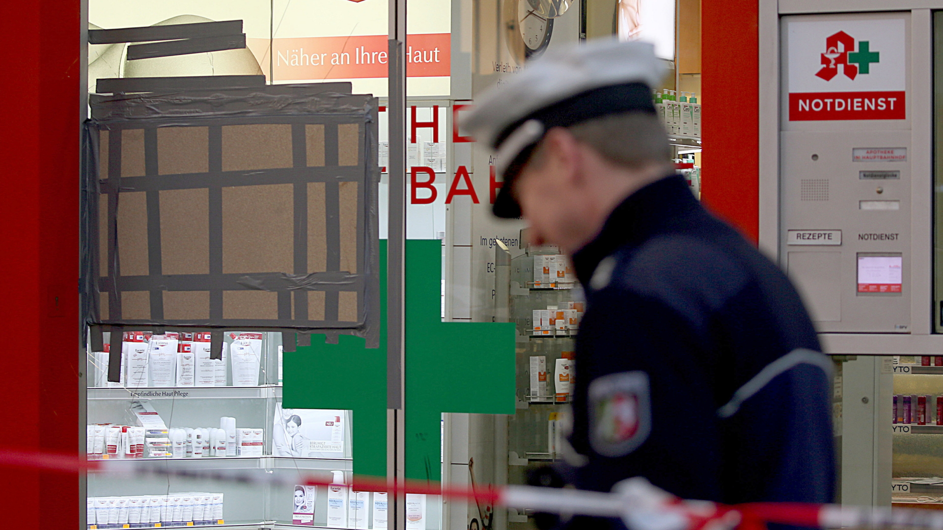 Ein Polizist steht vor der Apotheke am Kölner Hauptbahnhof, in der die Geiselnahme stattfand. | Bildquelle: dpa