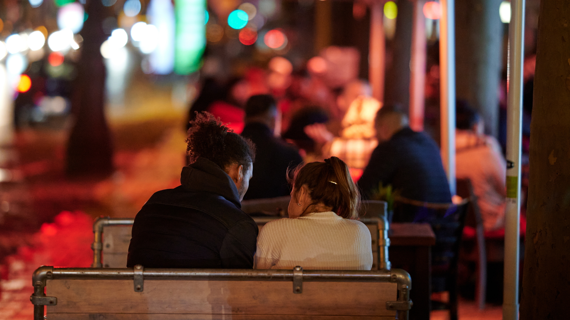 Ein junges Paar sitzt abends an einem Tisch im Außenbereich eines Restaurants auf den Ringen in Köln. | dpa