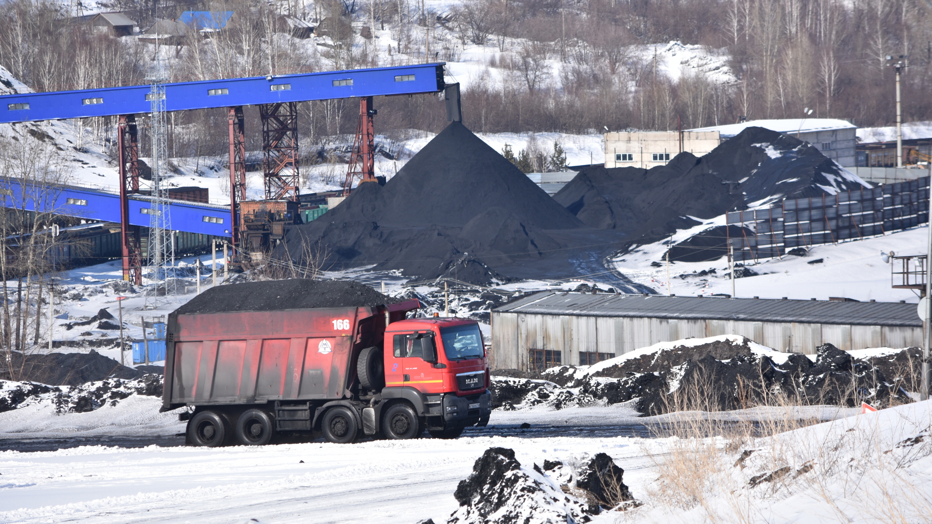 Ein Lastwagen transportiert Kohle in einer vershcneiten Landschaft in Russland. | dpa