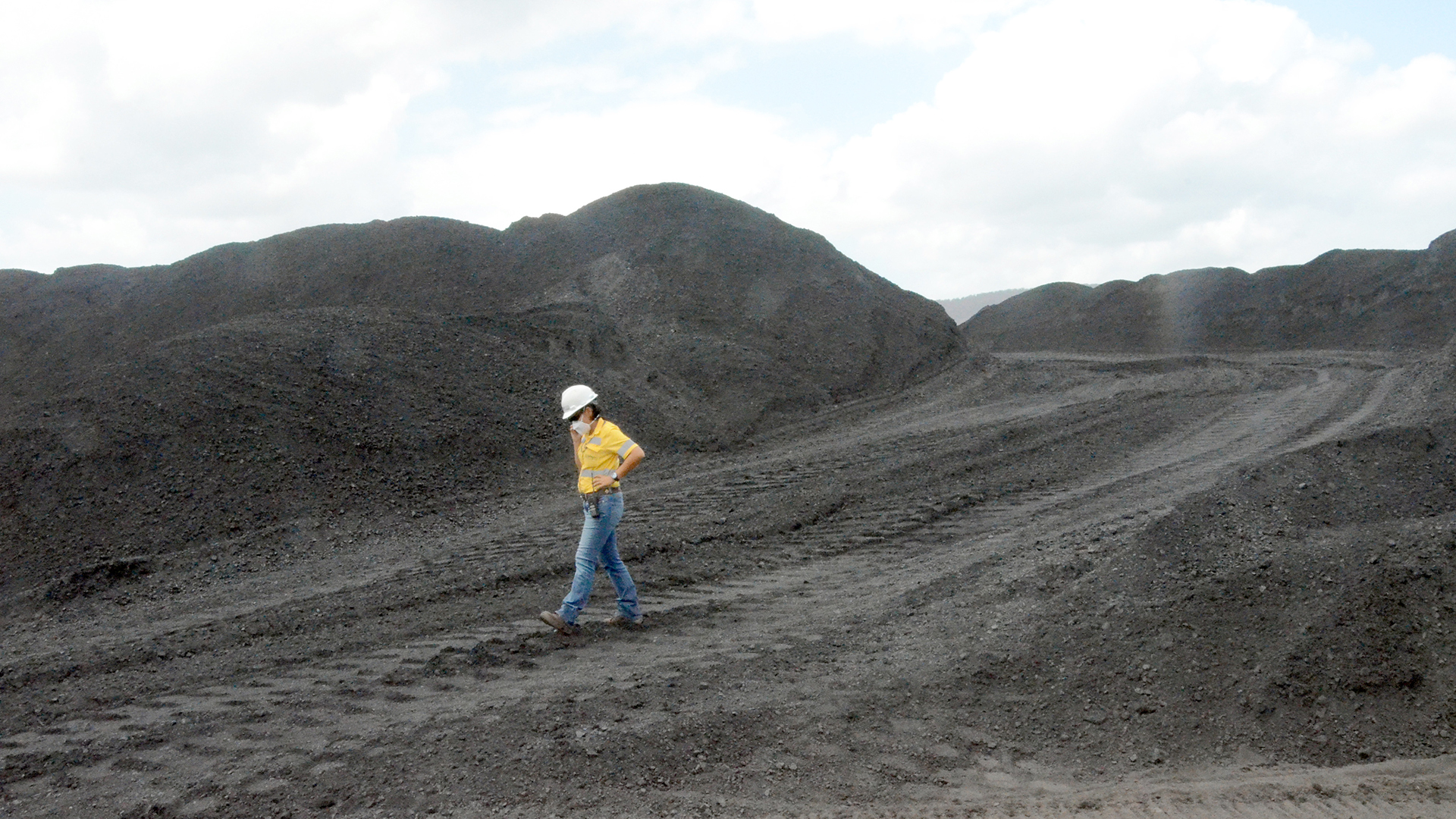 Eine mit einem Mundschutz ausgerüstete Mitarbeiterin inspiziertden Kohleabbau im größten Tagebau Lateinamerikas "El Cerrejón" in Kolumbien. | picture alliance / Georg Ismar/d