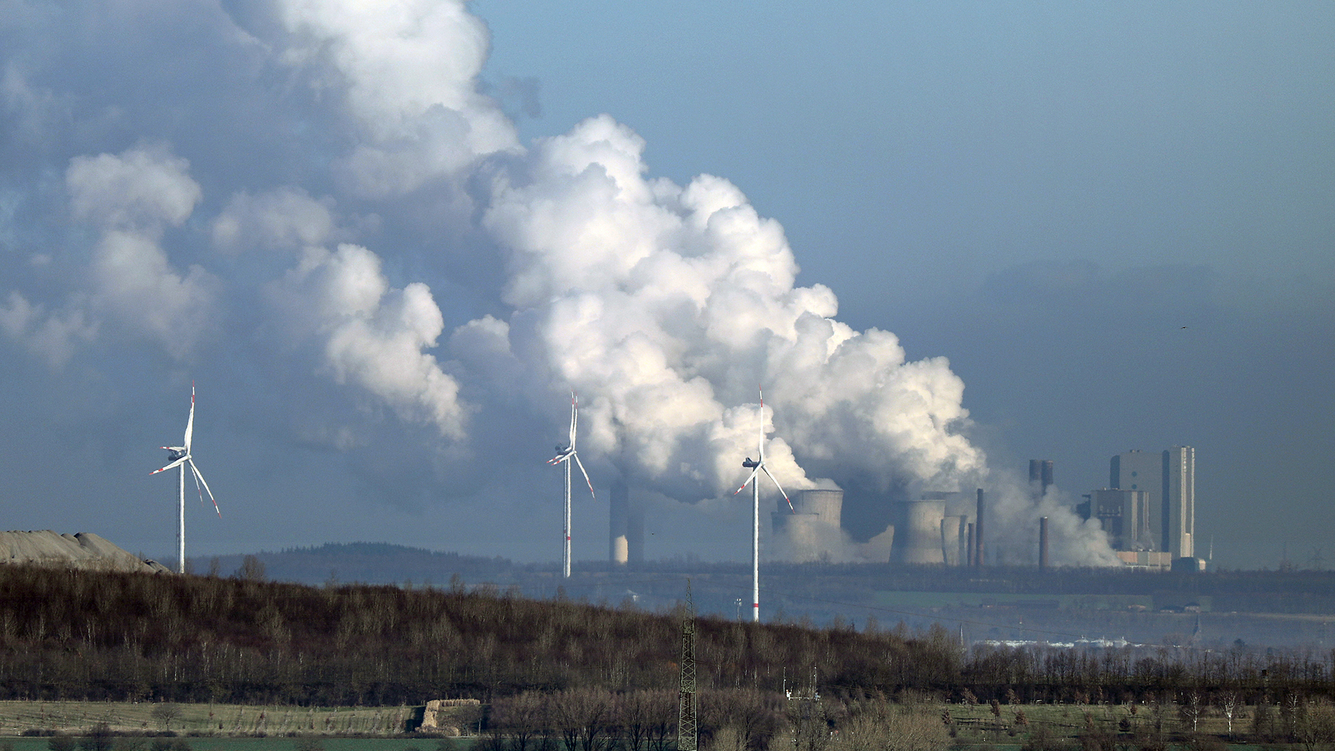 Windräder drehen sich vor dem RWE-Kraftwerk Neurath | dpa