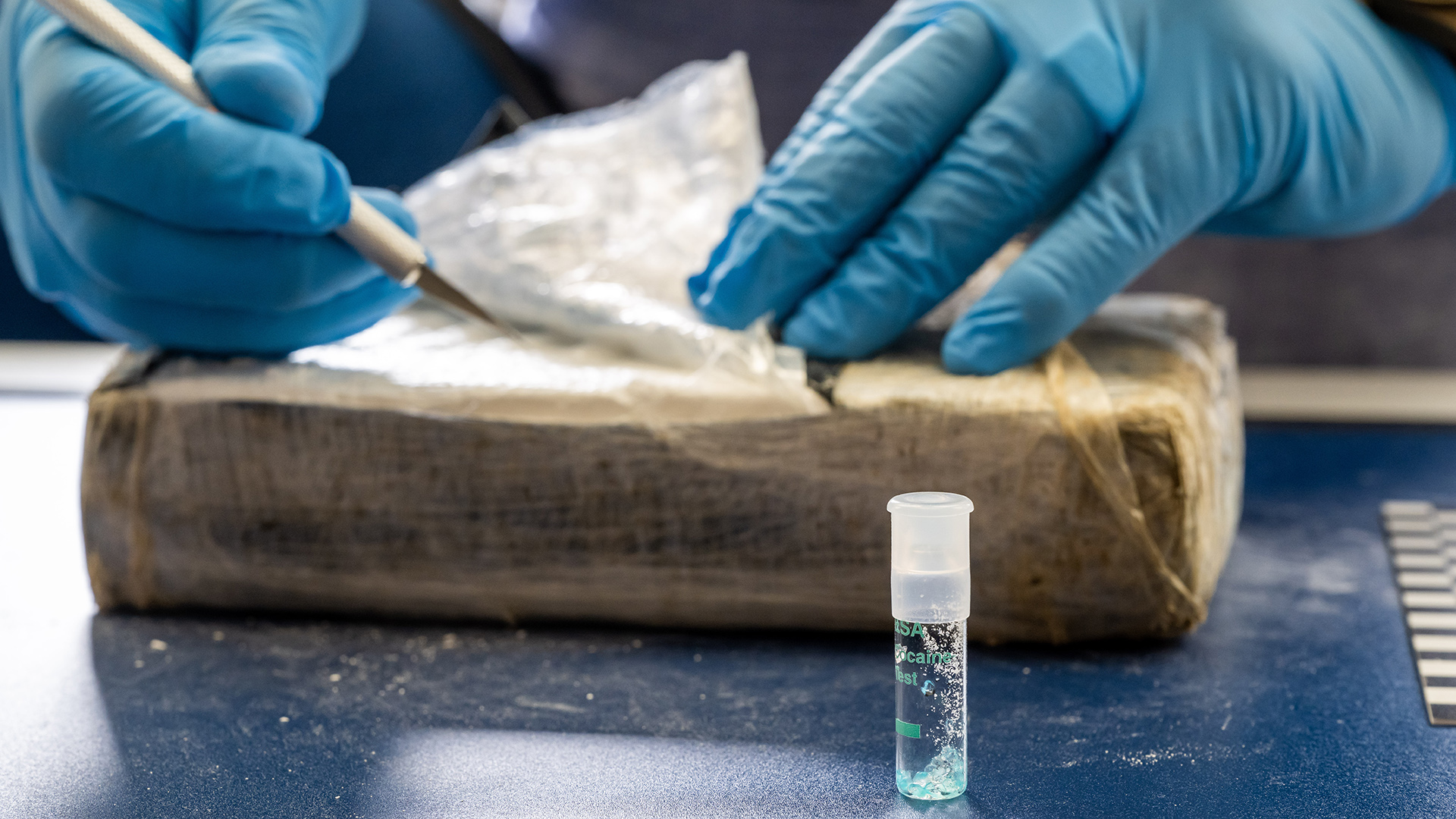 Ein Zollbeamter nimmt eine Probe von einem Kokainfund, die mittels einem Teströhrchen untersucht wird. | picture alliance/dpa