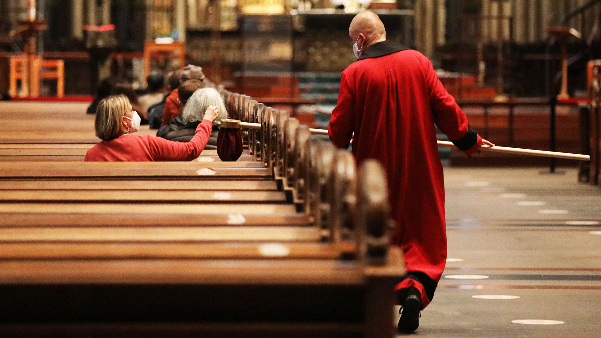 Ein Domschweizer sammelt während des Gottesdienstes im Kölner Dom die Kollekte ein | dpa