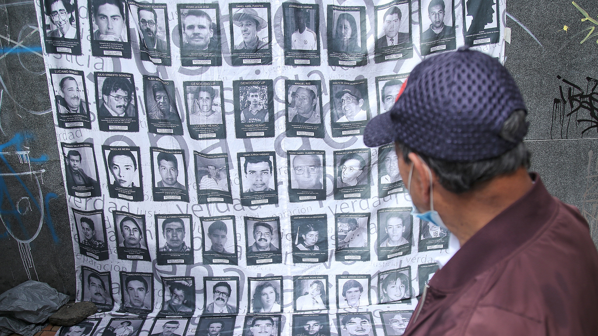 Ein Mann betrachtet Bilder von Todesopfern des internen Konflikts in Kolumbien. | dpa