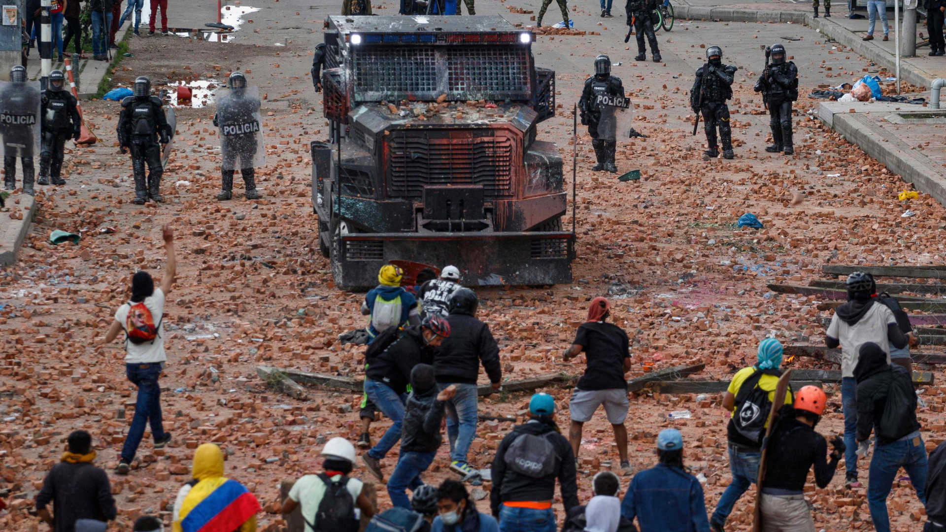 In der kolumbianischen Stadt Cali stehen Demonstranten einem Räumfahrzeug und mehreren Polizisten gegenüber. | AFP