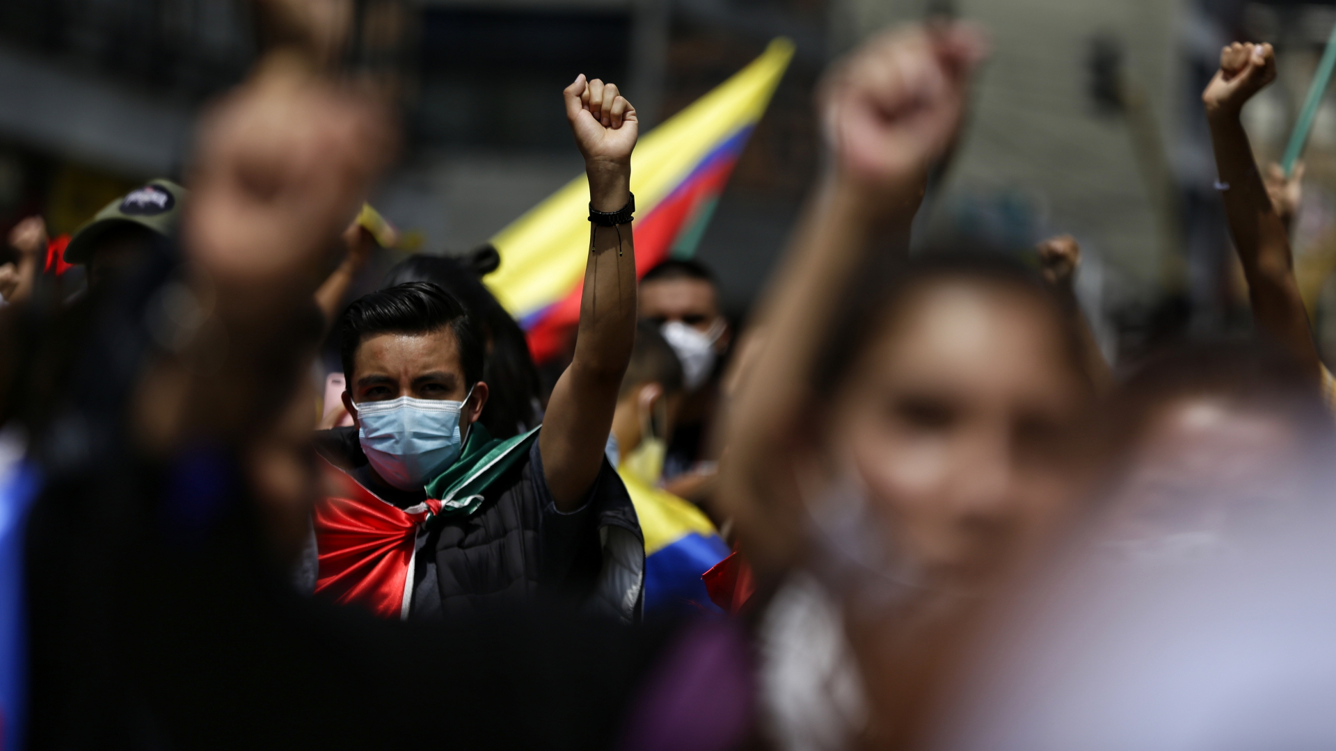 In Bogotá protestieren Anfang Mai 2021 Menschen mit kolumbianischen Flaggen und hochgereckten Fäusten. | dpa