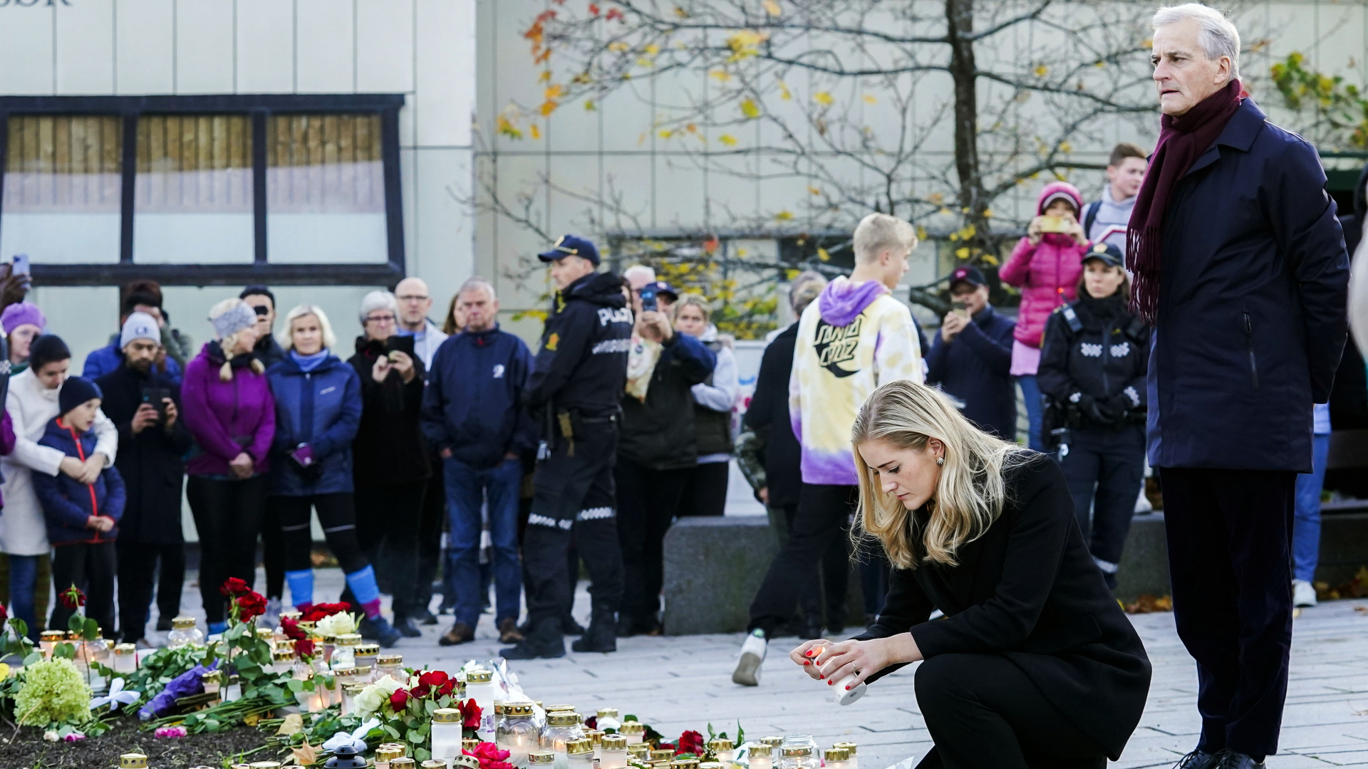 Jonas Gahr Støre (r), Ministerpräsident von Norwegen, und Emilie Enger Mehl (2.v.r), Justizministerin von Norwegen, legen bei ihrem Besuch in Kongsberg Blumen für die Opfer eines Attentats nieder und zünden Kerzen an. | dpa