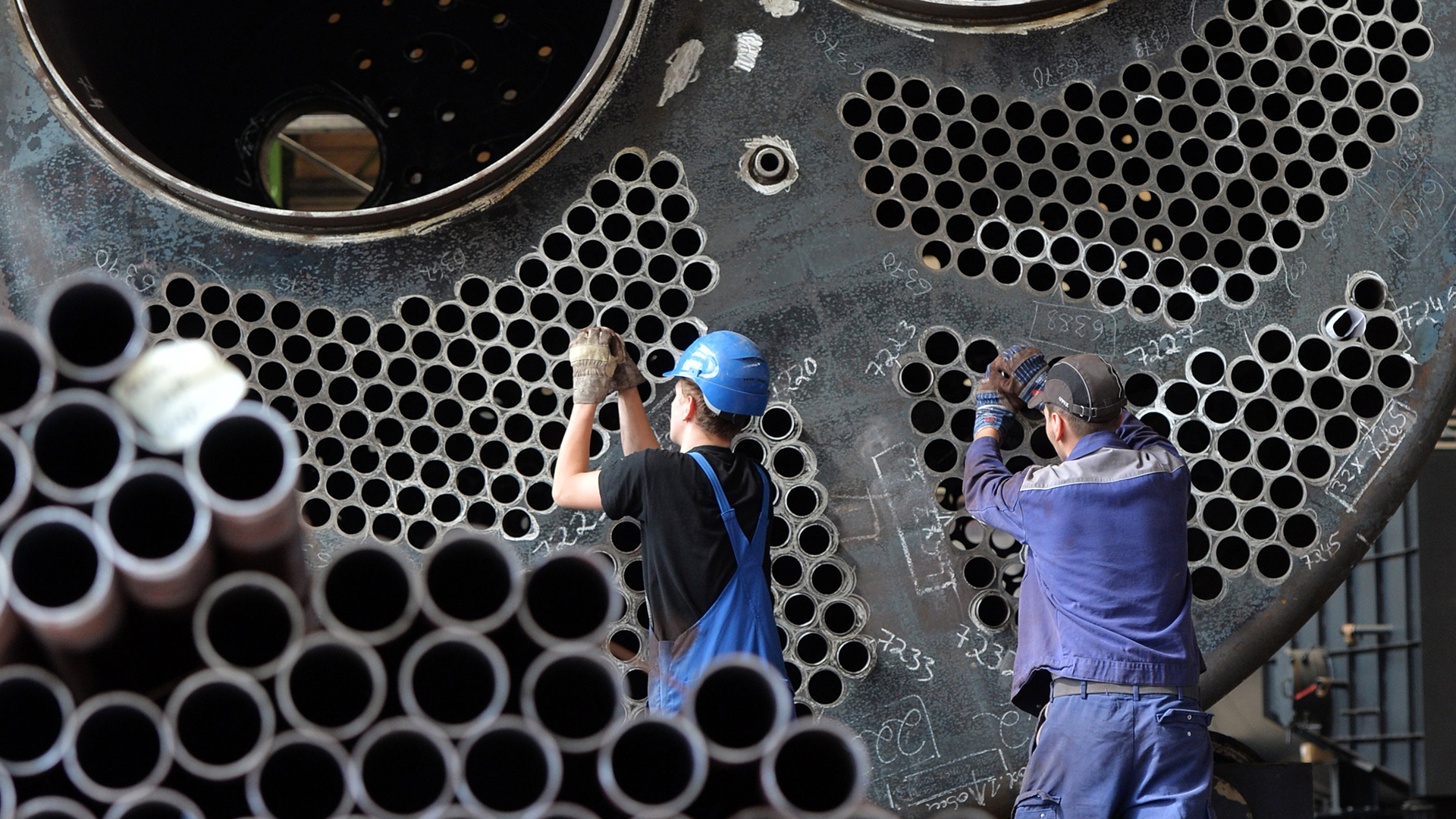 Mitarbeiter eines Anlagenbauers arbeiten an einem Gasbrennkessel | dpa