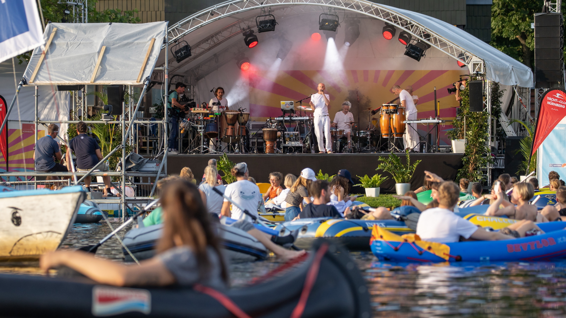 Die Band Orange spielt ein Konzert auf der Seebühne am Großen Dutzendteich in Nürnberg vor Zuschauern, die auf ihren eigenen Booten das Konzert verfolgen. | dpa