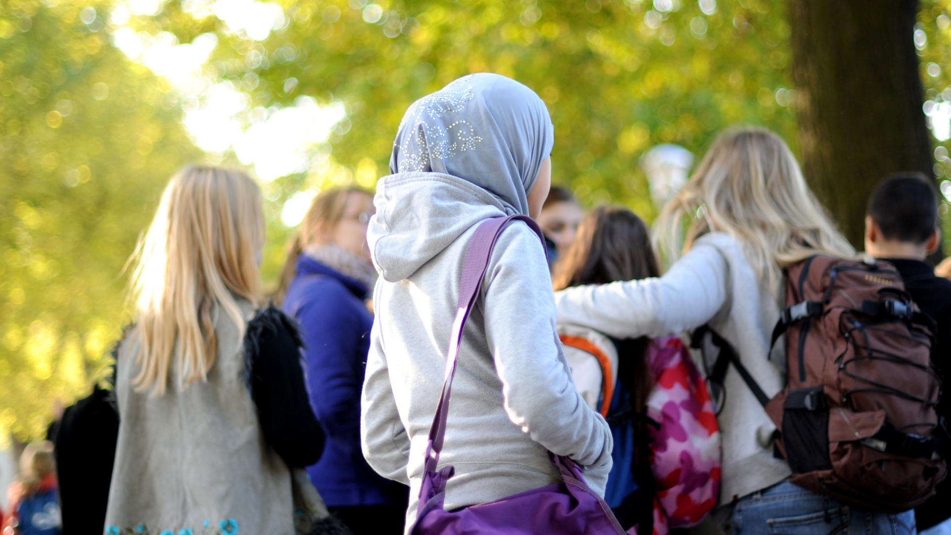 Ein junges Mädchen trägt ein Kopftuch auf dem Schulhof. | dpa