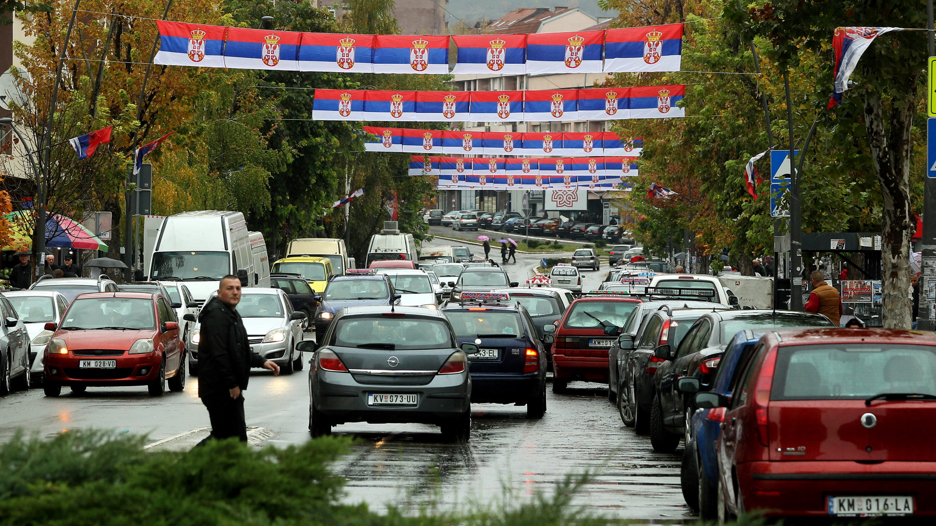 Autos fahren durch eine mit serbischen Flaggen geschmückten Straße in Mitrovica, Kosovo. | EPA