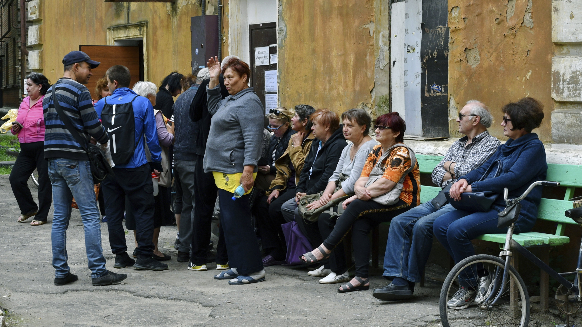 Menschen warten auf einer Bank in Kramatorsk auf Hilfsgüter. | AP