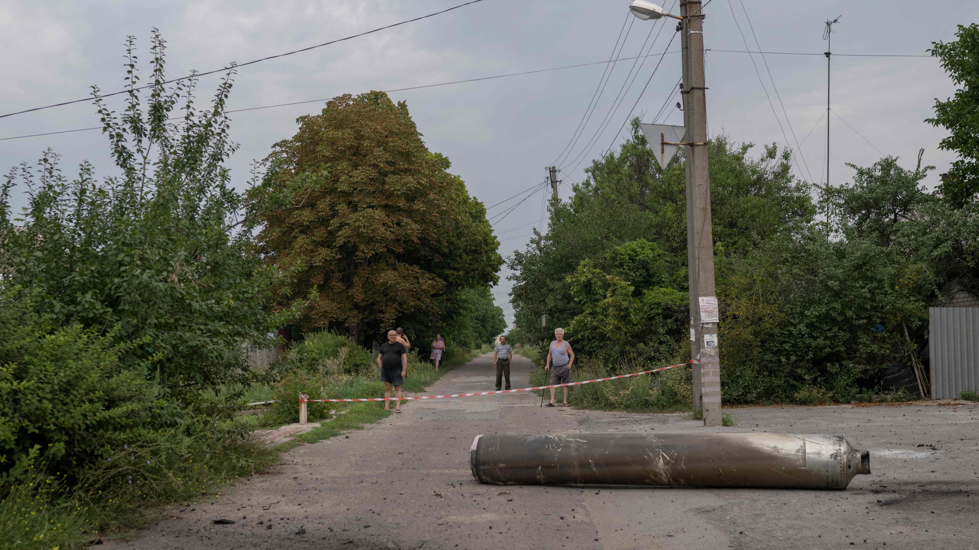 Die Menschen schauen in der Nähe eines abgesperrten Raketenstücks zu, das in Kramatorsk während der russischen Invasion in der Ukraine gelandet ist.