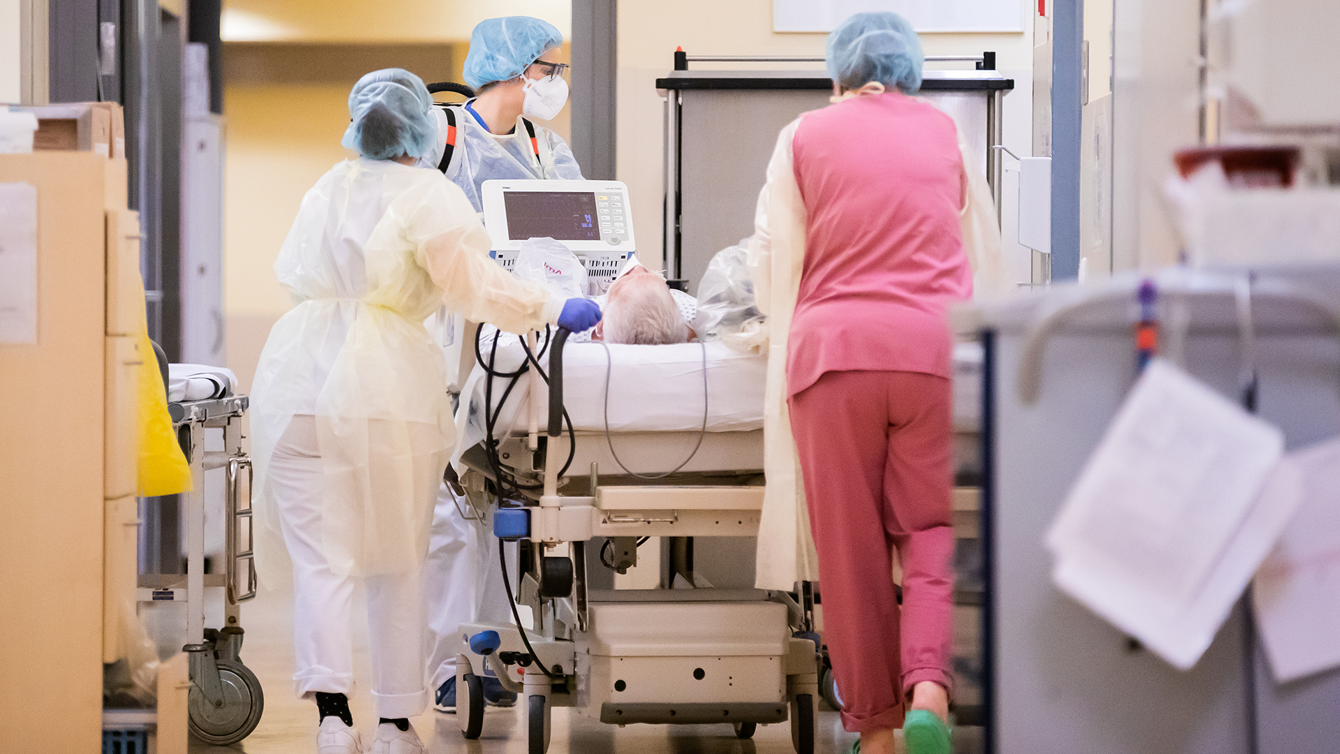 Eine Assistenzärztin schiebt mit Intensivfachpflegerinnen auf der Intensivstation des Gemeinschaftskrankenhauses Havelhöhe in Berlin das Krankenbett eines Covid-19-Patienten.