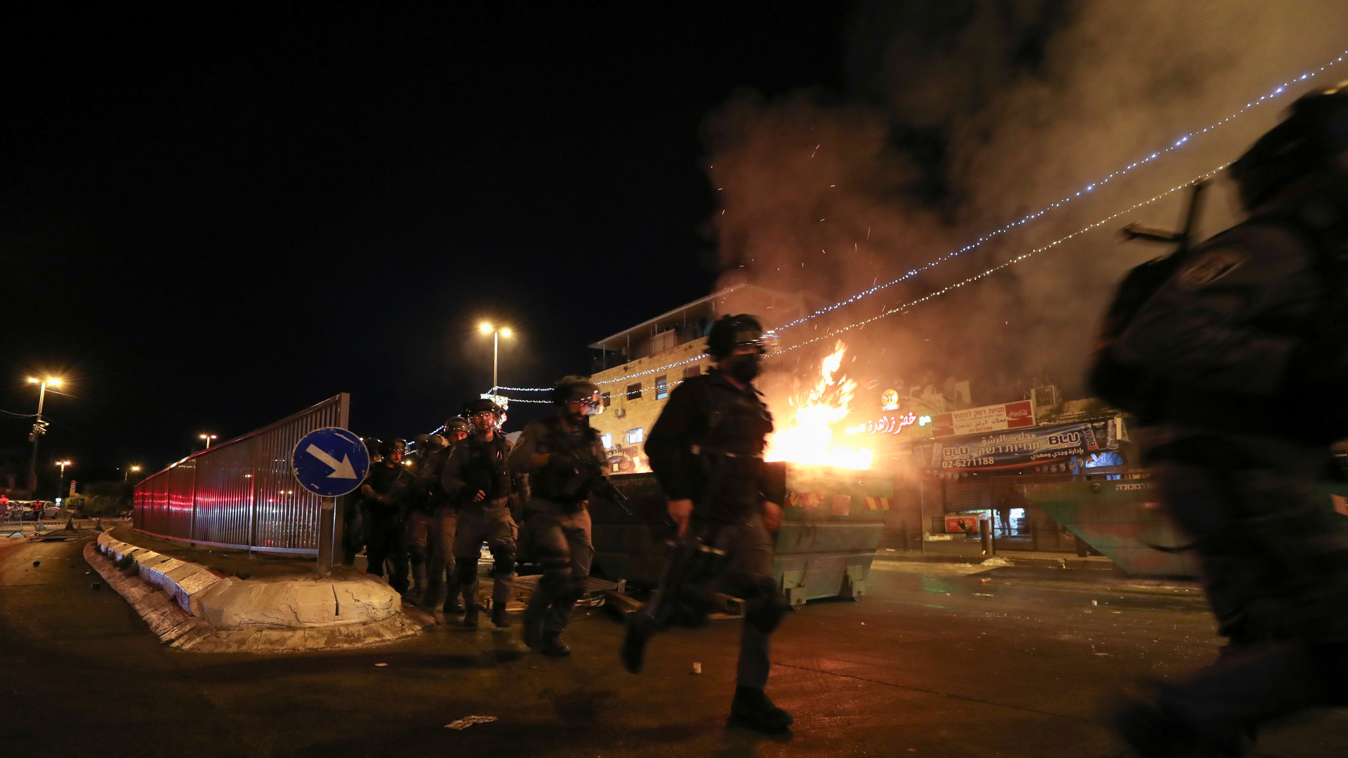 Polizisten in Jerusalem laufen an einem brennenden Müllcontainer vorbei | REUTERS