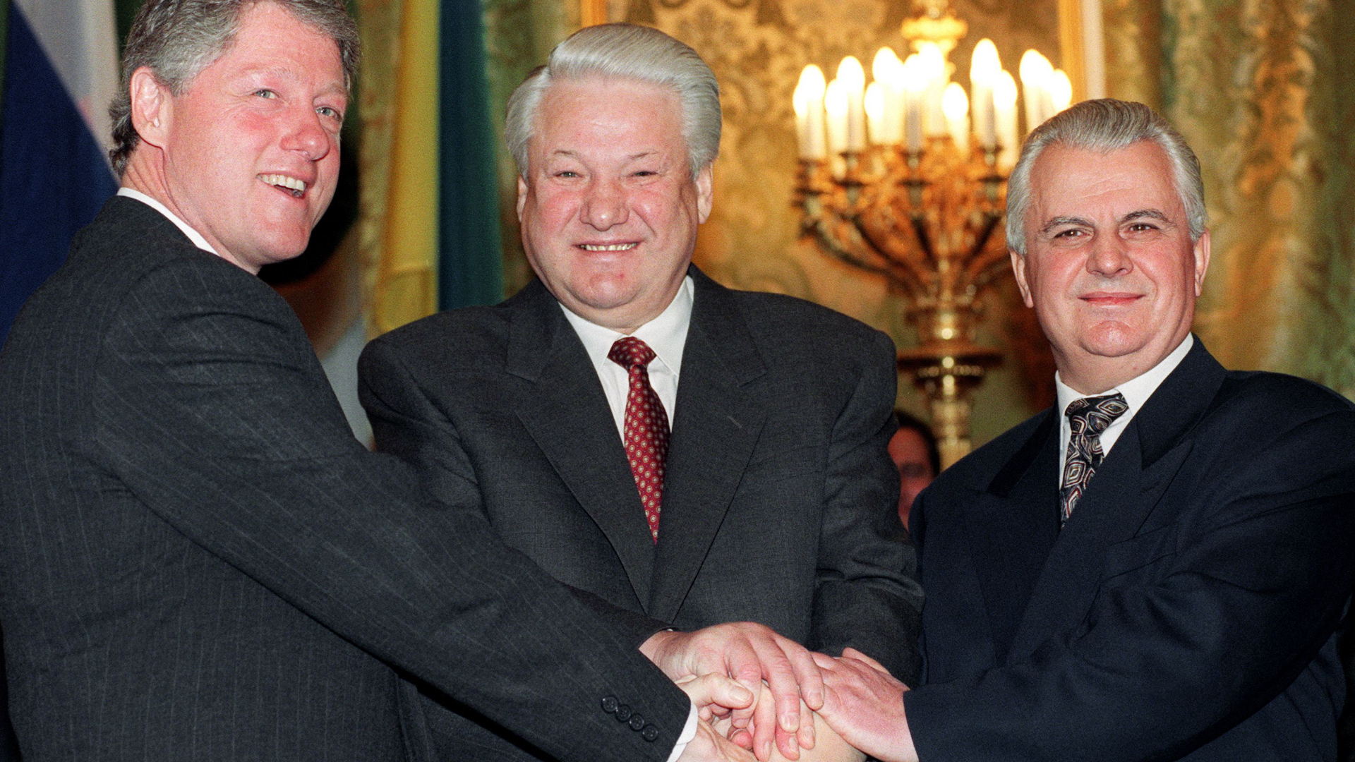 Leonid Krawtschuk (rechts), Boris Jelzin (Mitte) und Bill Clinton (links) schütteln sich im Kreml die Hände nach der Unterzeichnung eines nuklearen Abrüstungsabkommens (Aufnahme von 1994). | AFP