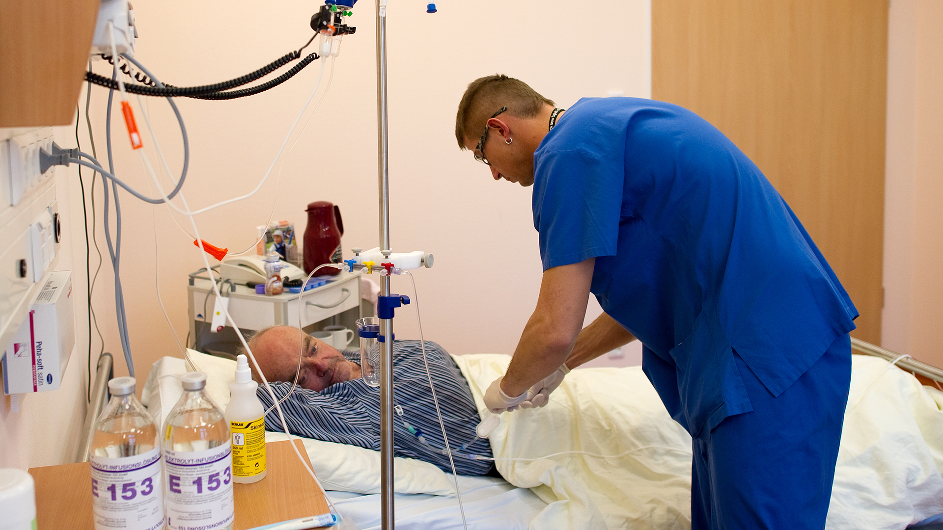 Ein Krankenpfleger wechselt eine Kanüle bei einem Darmkrebs-Patienten. | picture alliance / ZB