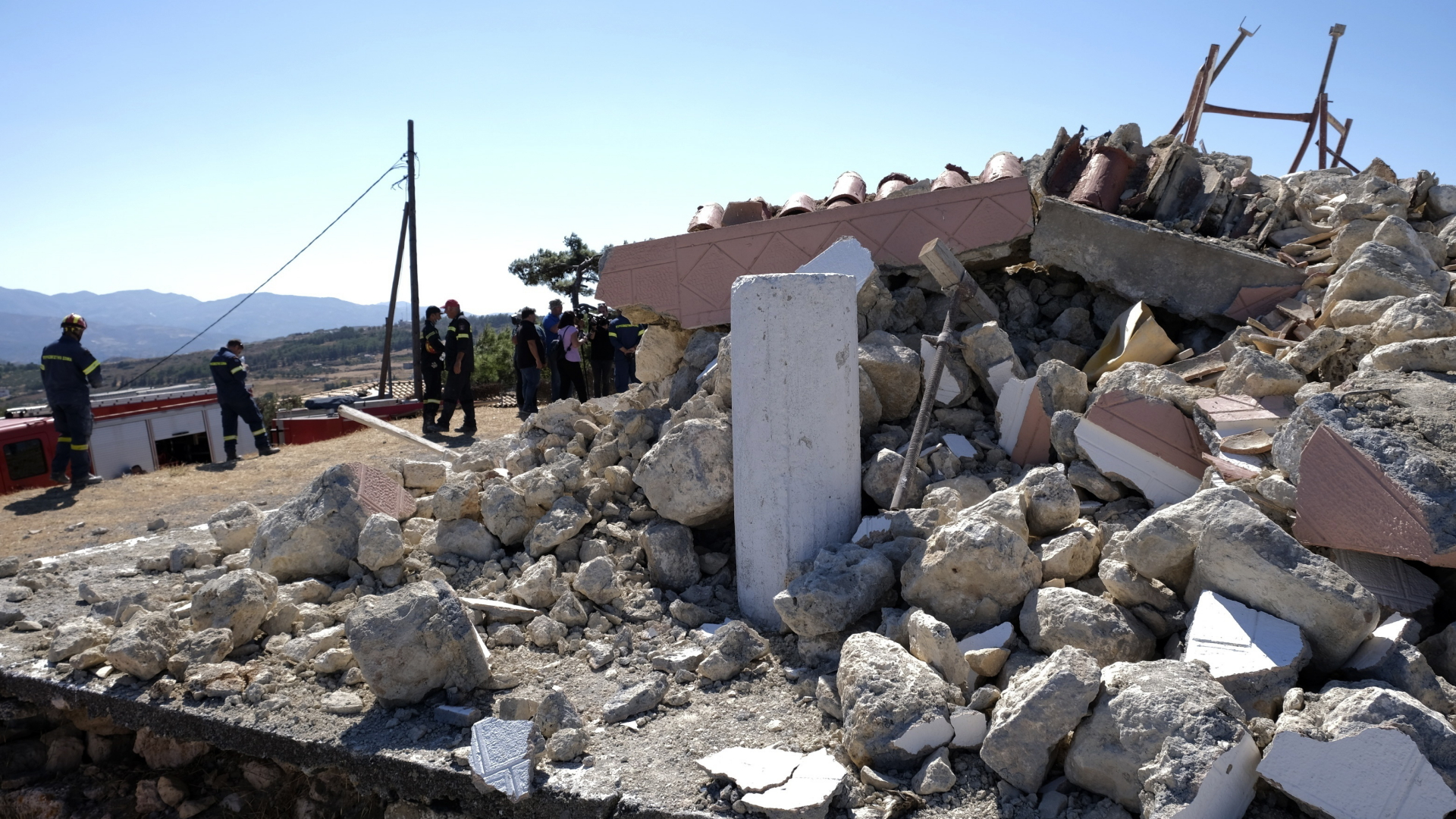Feuerwehrleute stehen neben einer zerstörten Kirche, nachdem das Dorf Arkalochori im Süden der Insel Kreta von einem Erdbeben erschüttert wurde. | dpa