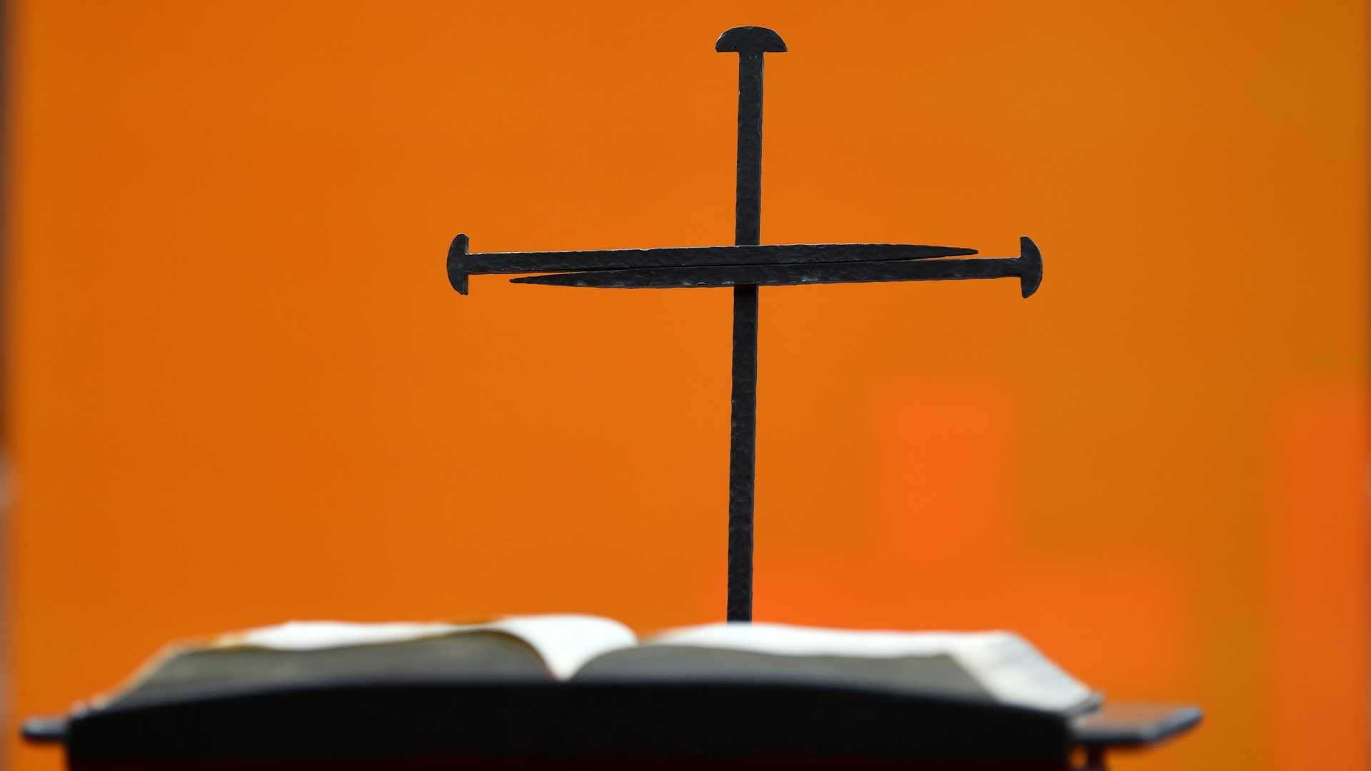 Ein Nagelkreuz steht hinter einer Bibel | 